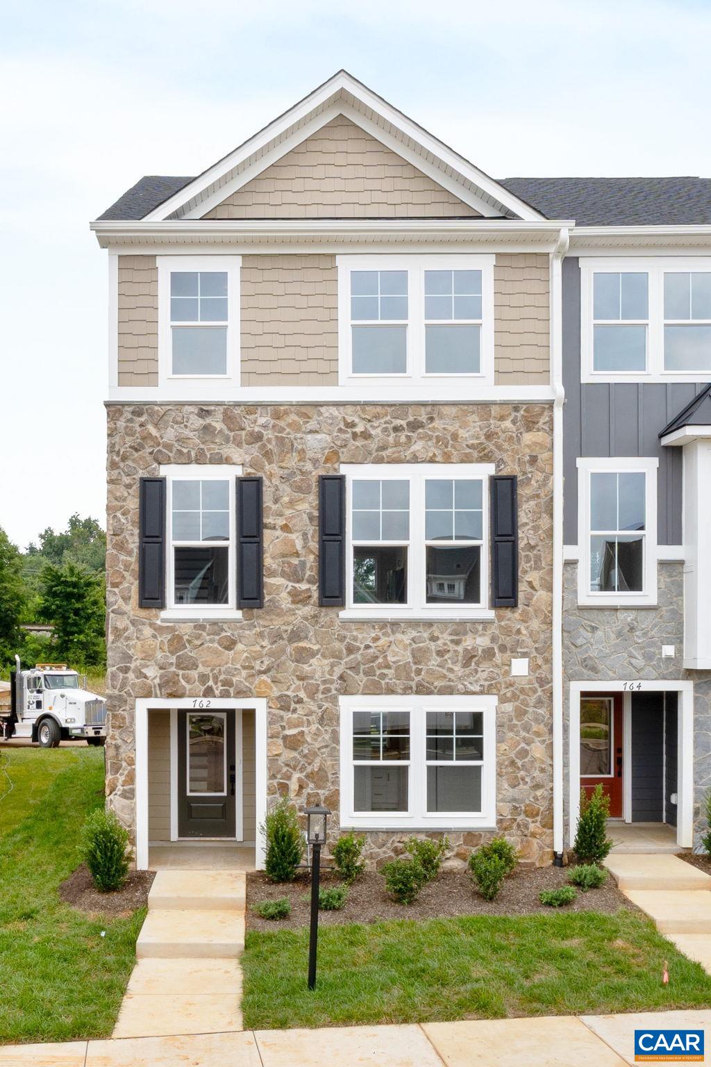 Just completed - actual photos! This end unit Poplar II townhome in Glenbrook offers a comfortable, farmhouse-style layout surrounded by mountain views, green spaces, and walking trails—all within easy reach of downtown Crozet. This interior unit features a bright kitchen with plenty of prep room and a walk-in pantry, a spacious rear deck off the main level, and a first-floor bedroom with its own full bath that works well for guests or a home office. You'll find thoughtful touches throughout, like oak stairs, solid core interior doors, wood shelving, and an energy-efficient furnace. A two-car garage is included for added convenience. Community perks include a nearby path to Crozet Park and future access to downtown via a planned trail.