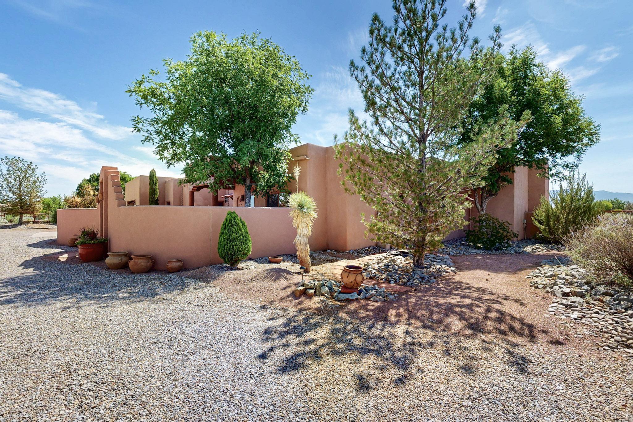 Discover this custom designed upgraded & meticulously maintained stylish Corrales casa. Offering lovely  views of the sizzling sunsets against those majestic Sandias! Custom double gated entry courtyd w flagstone patios & pathways. Warm & inviting the moment you step inside.Spacious living/dining areas w soaring Viga T&G ceiling & wood burning Kiva  FP. Spiral pillars, corbels & artistic barn doors add just the special look. Expansive Kit updated w granite countertops, Hi End SS appliances w/ a 6 burner gas stove & enjoy the delightful eating bar.Awesome backyd w great living spaces.Entertainers Delight. Outdoor island bar.12x16 Art Studio/ Music/office? Relax on the cozy cabana. Gardeners welcome too. Meandering patios & walkways. Men..check out the awesome/workshop(3rd bay). ++Tuff Shed