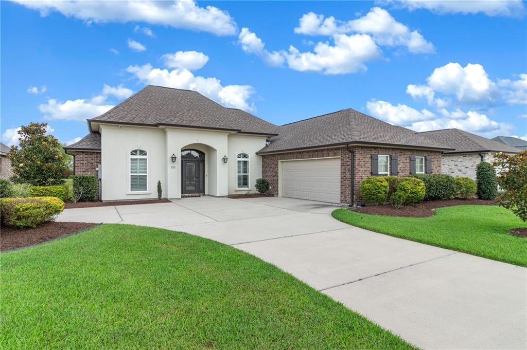 Welcome to this stunning 4-year-old home located in The Cove of Ashton Plantation, just minutes from I-310! Designed with exceptional craftsmanship, this residence showcases soaring ceilings, rich crown molding, and wood flooring throughout. The spacious great room features an 11' tray ceiling, a brick-accented mantle fireplace, and custom built-in cabinetry—great for relaxing or entertaining. Enjoy abundant natural light through windows adorned with custom plantation shutters and blinds. The gourmet kitchen boasts granite countertops, GE stainless steel appliances, a five-burner gas cook-top with pot filler, built-in oven and microwave, and an oversized island. Host with ease in both the formal dining room and the cozy breakfast nook. Retreat to the elegant primary suite featuring a tray ceiling, crown molding, and a spa-like bath with dual vanities, soaking tub, glass walk-in shower, and a spacious walk-in closet. With four bedrooms and three full bathrooms, there’s plenty of room for everyone. French doors open to a covered patio—great for outdoor entertaining. This beautiful home is full of thoughtful upgrades and refined finishes. Homeowners enjoy access to the community center pool and playground, both covered by HOA fees. Schedule your private showing today and experience all it has to offer!