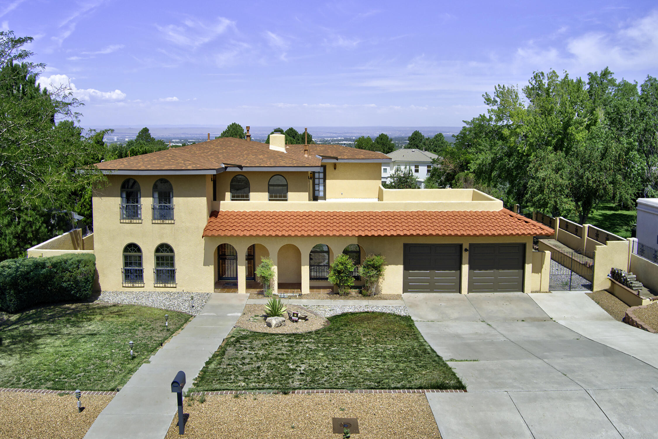 Discover this remarkable 5-bedroom, 5-bathroom home featuring two spacious living areas, a large office with custom wood built-ins, a bright sunroom, and quality Pella windows throughout. The kitchen boasts city views, double ovens, a breakfast bar, and a dedicated dining area. The spacious primary suite provides rooftop deck access, dual vanity sinks, a separate bath/shower, and an expansive walk-in closet. Enjoy the large lot with backyard access offering endless possibilities plus a spectacular rooftop deck with mountain and city views. Both roofs are under one year old.Located just minutes from The Canyon Club (with golf, tennis, & swimming), Kirtland Air Force Base, shopping, & scenic hiking trails. Call this home before it's too late!
