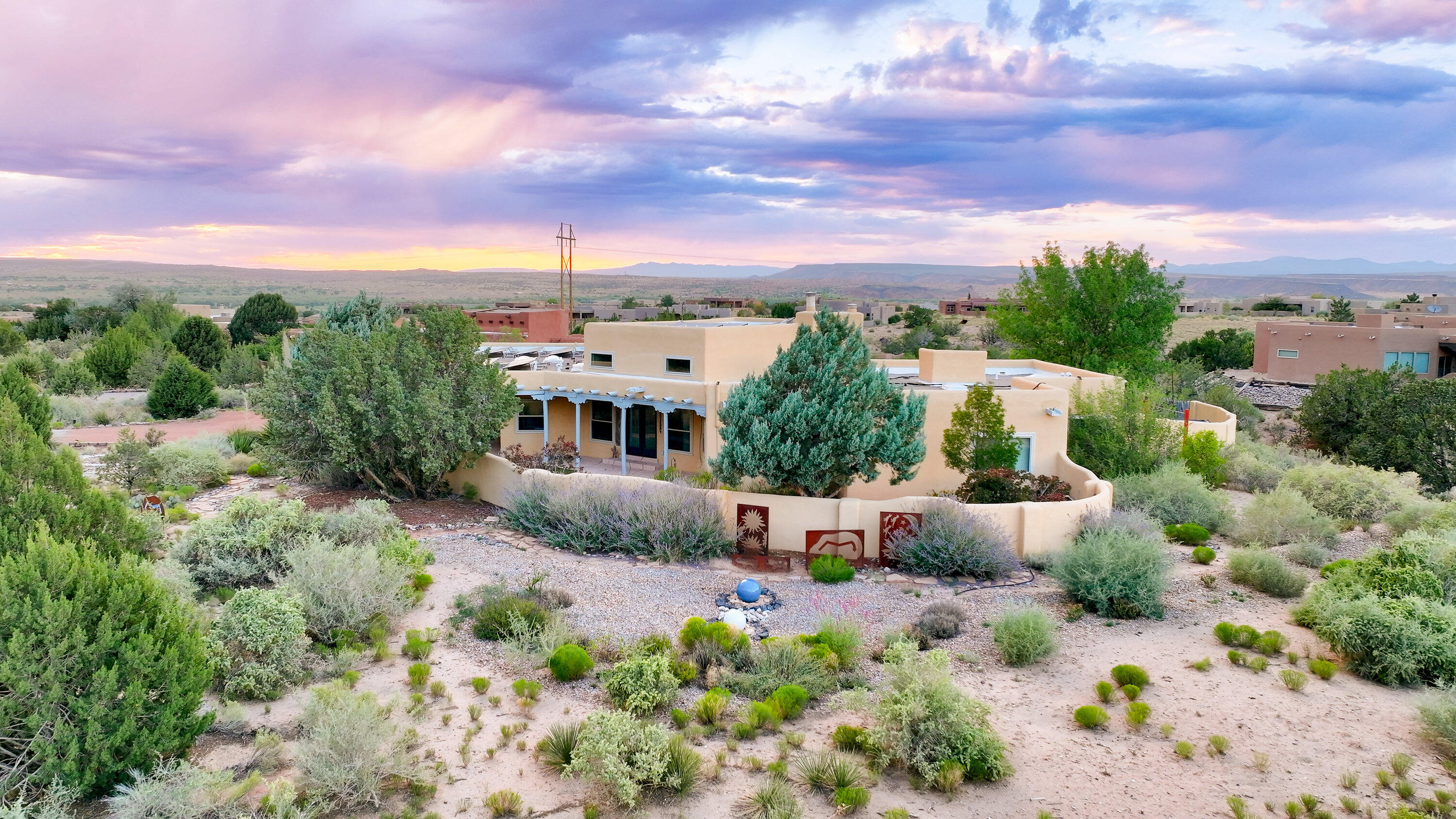 Melt into the serenity of Placitas living in your adobe-style home with soaring eastern views of the Sandia Mountains & western views of the Jemez range. A peak indoor-outdoor living home with a covered front patio, enclosed front courtyard, & enclosed back yard with an incredible sun deck. The entire home is electric, and with owned solar panels, utility bills run incredibly low year-round. Enjoy refrigerated air conditioning and heating that is climate controlled in each room through the mini split system. The living room has wooden beam-adorned high ceilings, saltillo tile flooring, & warm adobe walls centering around a wood burning fireplace. Cook in style in your functional kitchen with talavera tile countertops & abundant cabinetry & storage.