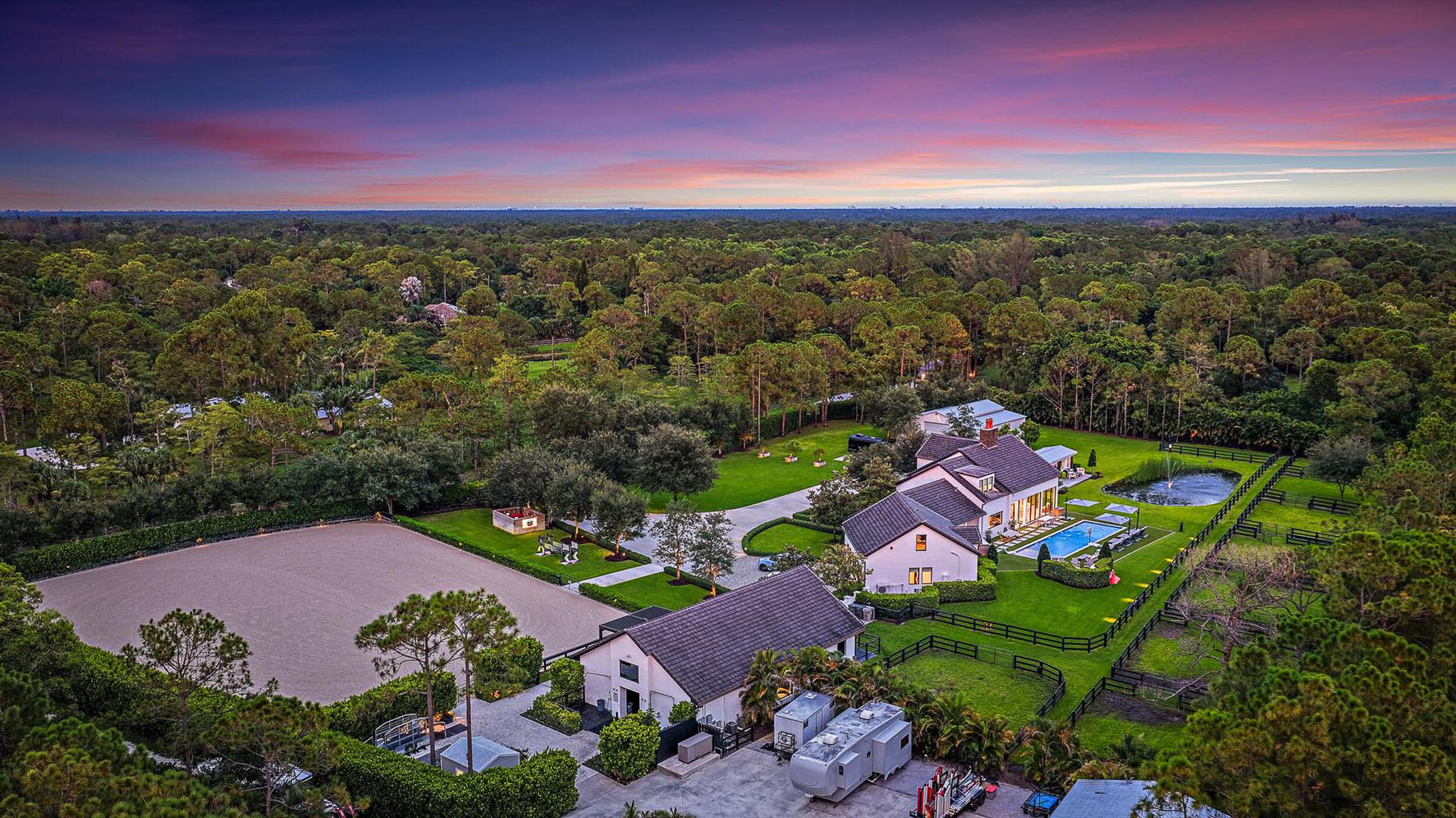 This completely reimagined estate combines timeless charm with modern luxury on 5 private acres in Palm Beach Gardens' coveted equestrian community of Caloosa. Designed as a full retreat, it offers open, sun-filled living spaces and resort-quality amenities inside and out.Walls of windows frame the flowing layout, connecting the designer kitchen, dining area, and inviting living spaces. The primary suite features a morning bar, custom wardrobe closets, and a spa-style bath. Multiple guest suites and a luxury in-home cinema provide space for everyone to unwind.A fully automated Control4 smart home system with Josh AI manages lighting, climate, entertainment, and security--delivering convenience to match the estate's beauty.The backyard is an entertainer's dream with a lap pool with a heater and chiller, turf lounging areas, built-in bar and fireplace, Coastal Source audio, and full landscape lighting.

Equestrian facilities include an 8-stall Wellington-style barn, full-size riding arena, multiple paddocks, and a separate gated entrance. 

A massive detached building houses car storage, a gym, classroom, and man cave, while a finished she-shed serves as an ideal home office. Additional amenities include a pole barn, 1,500-gallon buried propane tank, 500-gallon gas and diesel storage, whole-house generator, and mature privacy hedging.

Finished with craftsmanship and detail often seen in $15M+ Palm Beach Island estates, this property offers elegance, privacy, and functionality. Caloosa features 30 miles of riding trails, a 32-acre equestrian park, and a location just minutes from the best of Palm Beach Gardens-yet this home has everything you need without ever leaving.