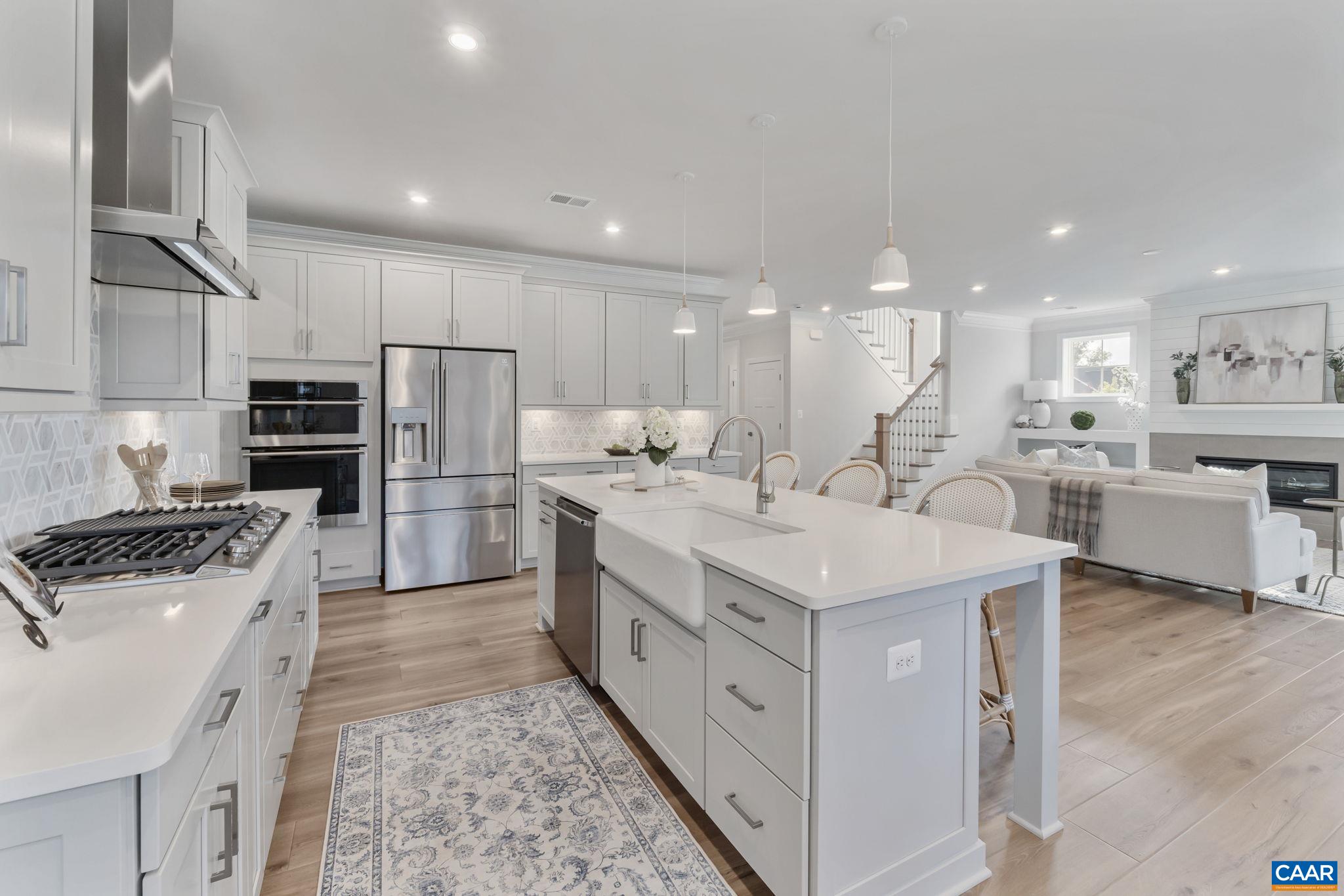 Set on one of the best remaining lots in Belvedere, this never-occupied former model enjoys a premier corner location buffered by the Rivanna Trail for added privacy and natural beauty. From the mahogany front door to the top-level terrace, every detail reflects thoughtful design and high-end craftsmanship. The open, light-filled main level features wide-plank LVP flooring, a 42” gas fireplace with shiplap and built-ins, and a gourmet kitchen with Electrolux appliances, quartz countertops, marble backsplash, soft-close cabinetry with custom pull-outs, and a large walk-in pantry. Step outside to a screened porch with a custom wood-burning stone fireplace—a perfect spot to unwind while enjoying the wooded backdrop and direct trail access. Upstairs, a versatile loft anchors three spacious bedrooms and a luxurious owner’s suite showcasing mountain views and a spa-worthy bath with a freestanding tub, dual vanities with backlit mirrors, a frameless glass shower, and a massive walk-in closet. The top-level loft with terrace adds another inviting space for relaxing or entertaining. From its rare corner lot buffered by nature to its impeccable finishes and flexible layout, this home combines elegance, comfort, and an unbeatable Belvedere.