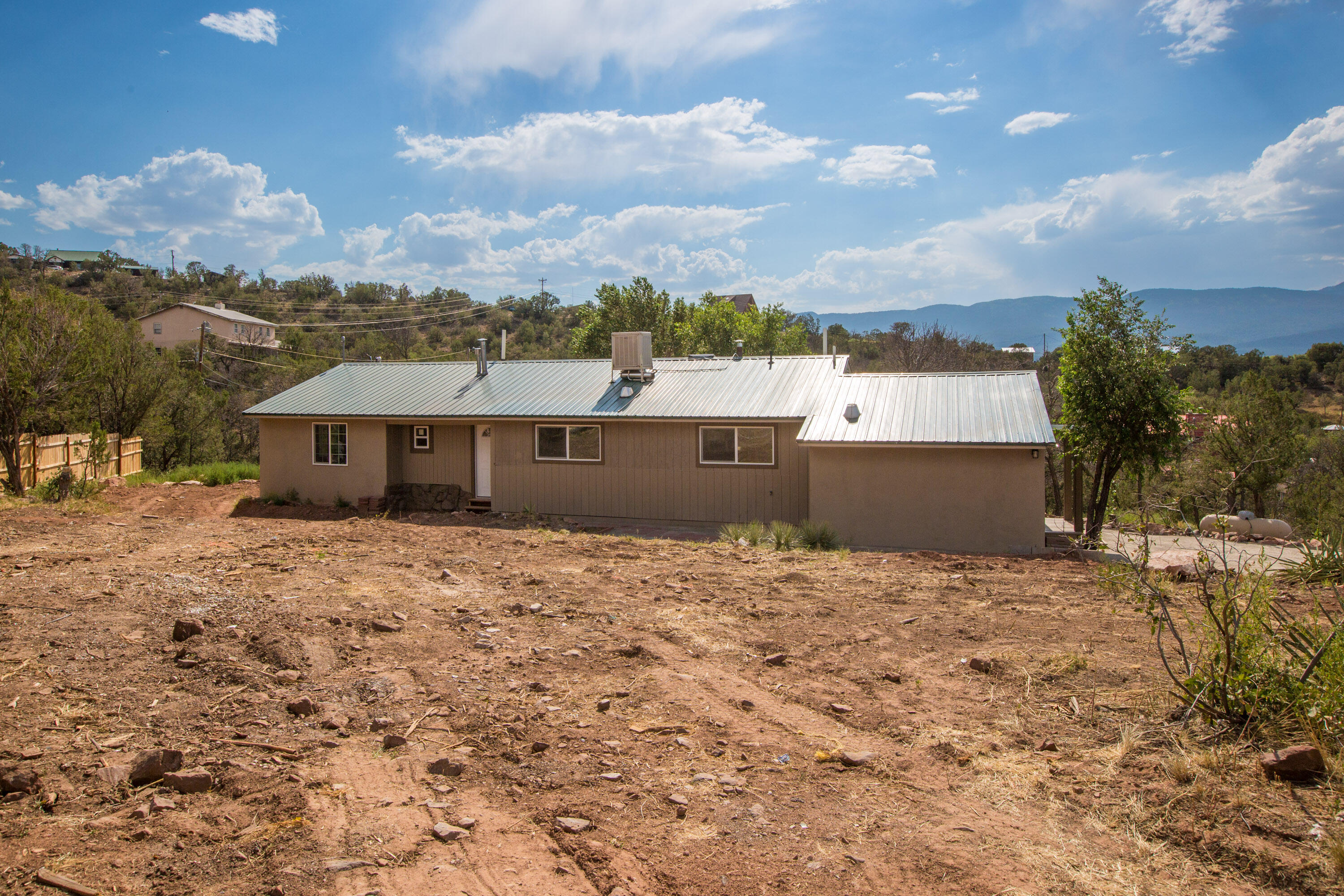 Welcome to your dream home in the serene Sandia Knolls neighborhood of Sandia Park, NM! Recently renovated from top to bottom, this 3-bedroom, 2-bathroom home with an additional office offers a perfect blend of modern upgrades and mountain charm. Step inside to an open floor plan filled with natural light, where refinished original wood floors showcase the home's timeless character. Relax in the spacious living area, or step out onto your brand-new back deck to soak in peaceful sunsets and the fresh mountain air. Whether you're sipping coffee on the deck, entertaining in the open living space, or working from your quiet office with views of the trees, this home offers the best of tranquil mountain living with modern style.