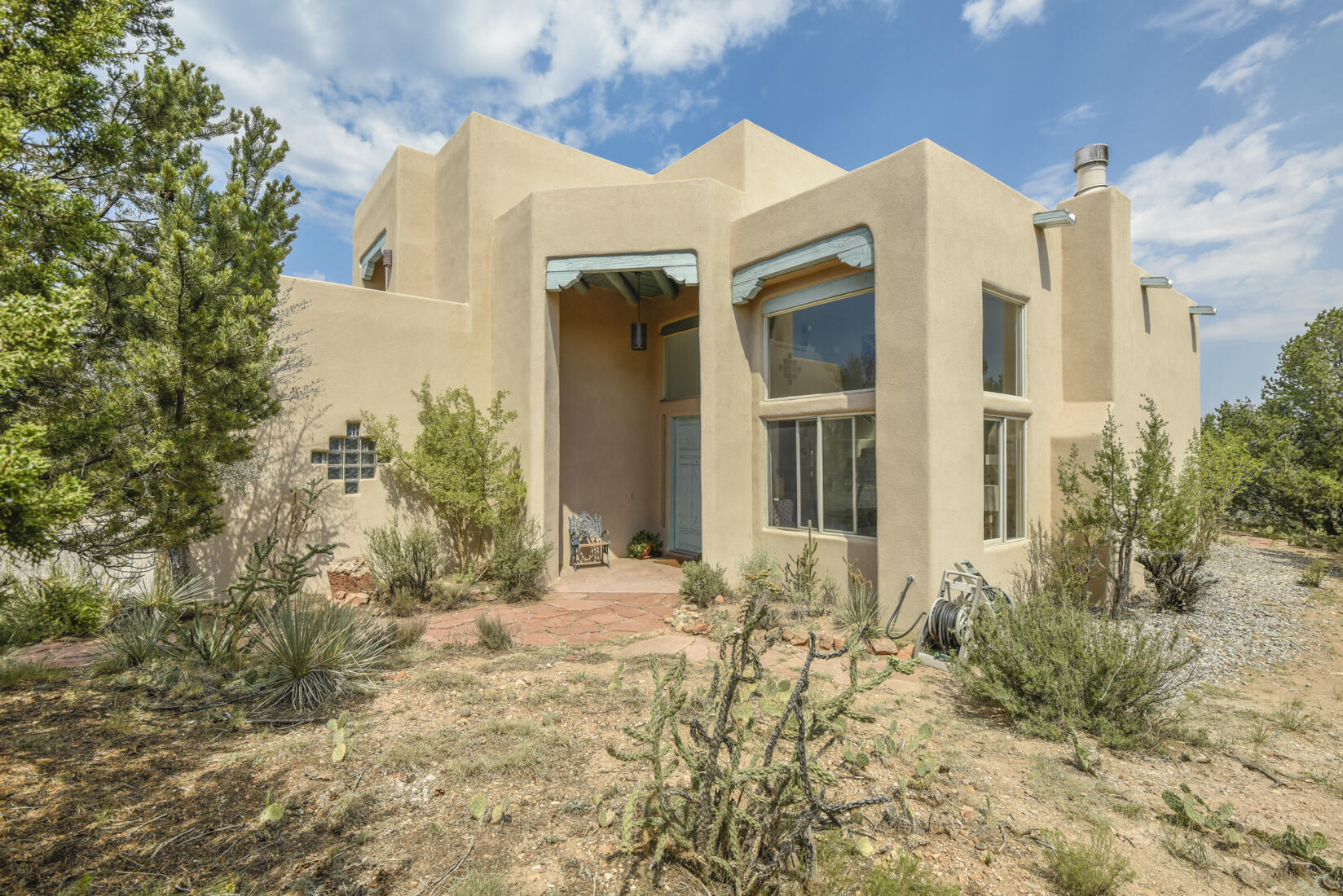 Welcome to this lovely custom home, designed and built for the current owner and rich with unique features. A grand Santa Fe Door welcomes you into a light-filled living space with a custom fireplace, exposed wood, and adobe accents. The open kitchen, breakfast area, and informal family room featuring a 2nd custom fireplace flow to a covered patio. A lower-level bedroom with a separate entrance and a close-by 3/4 bath offers flexibility. Upstairs includes a spacious main ensuite with panoramic views, two more bedrooms, a full bath, and two view decks. The 3-car garage includes an oversized bay with a raised door and ceiling for mid-size RV storage. A great Paa-Ko value and A must-see!