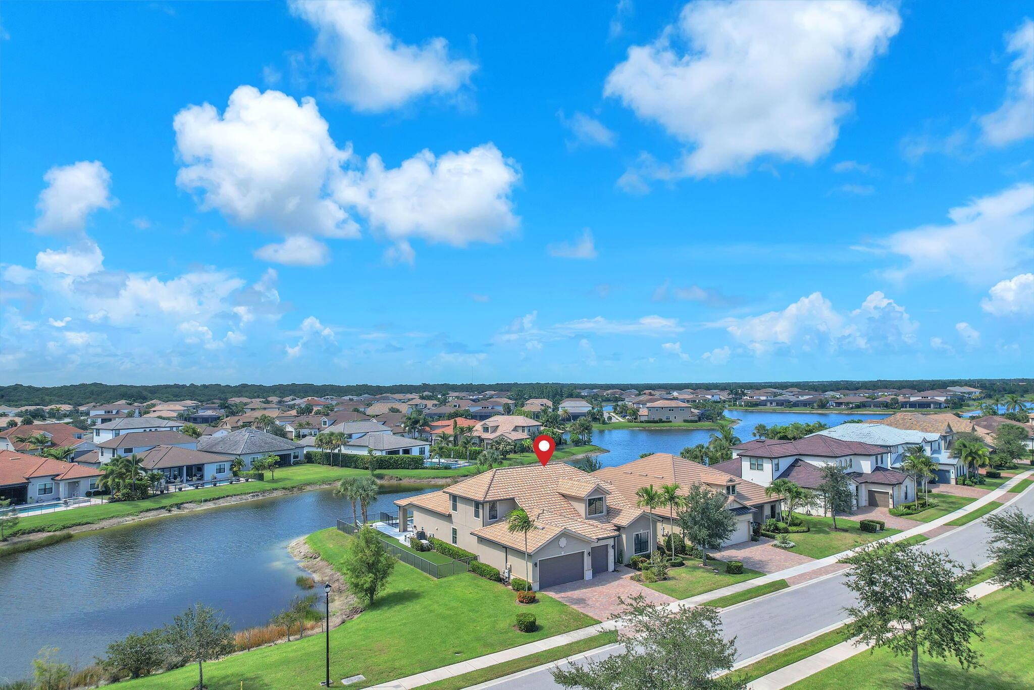 This stunning waterfront home, situated on a rare, ultra-premium corner lot, offers panoramic lake views from nearly every room. Enter through custom front doors into an elegant, contemporary residence featuring a spacious open floor plan and soaring ceilings that create an expansive feel. The chef's kitchen is a focal point, boasting gorgeous gray cabinetry, stainless steel appliances, a gas stovetop, double ovens, and a massive kitchen island. The home's modern flair is evident in its neutral color palette, upgraded wood-grain tile flooring downstairs, and dazzling light fixtures. The seamless indoor/outdoor flow between the living room and the patio makes this an entertainer's dream. Enjoy breathtaking lake views from your newly built, heated pool and jacuzzi, which were completed in 2022. The pool deck and patio feature beautiful marble-style stone and turf grass, creating a modern and low-maintenance outdoor space. For your peace of mind, the home is equipped with hurricane impact windows and doors, a NEMA 14-50 outlet for electric vehicles, and a water-cooled, whole-house generator installed in October 2021. Located in the highly desirable, Sonoma Isles community, you'll have access to a resort-style clubhouse with a sparkling heated pool, spa, fitness center, basketball, pickleball, and tennis courts, plus playgrounds and walking paths. The community is perfectly situated in Jupiter, Florida, with close proximity to world-class beaches, extensive shopping, fine dining, and "A" rated schools. A Jupiter Country Club membership is also available to the buyer.