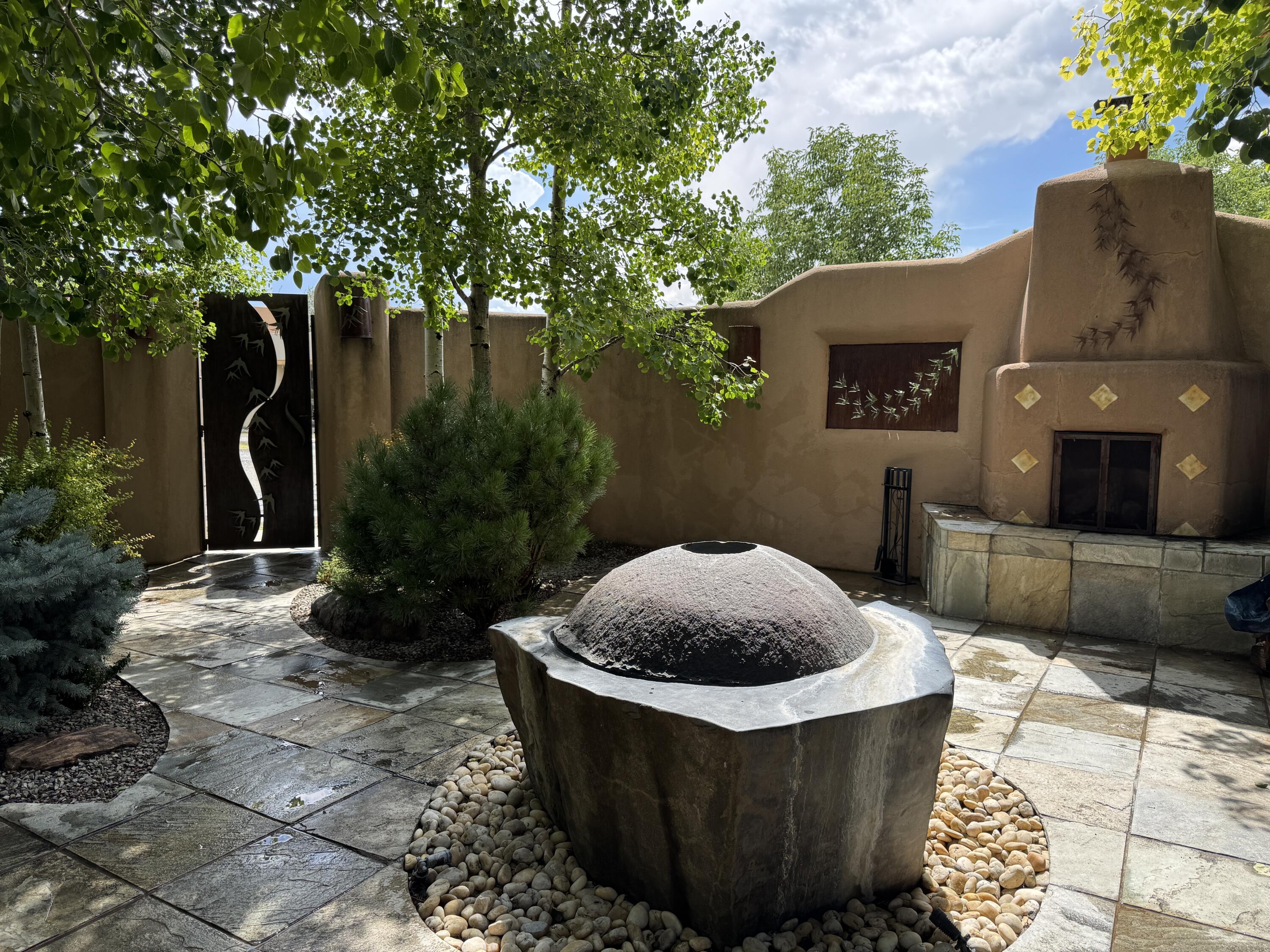 Under Contract Taking Backup Offers. Check out the magical courtyards in the coveted Oshara Village community home featuring abundant natural light and open concept living. The main house has 2 bedrooms and 2 bathrooms. High ceilings with skylights bring the outdoors in and large traditional southwestern vigas remind you that you are in the Southwest. The beautifully remodeled chef's kitchen features a KitchenAid gas stove and oven alongside a Samsung smart refrigerator. The spacious living room has gallery lighting throughout, perfect for your art collection. The wood burning kiva creates a quintessential Santa Fe ambiance with hand chiseled solid wood doors, top of the line window shades, stone tile are found throughout this dreamy home.
