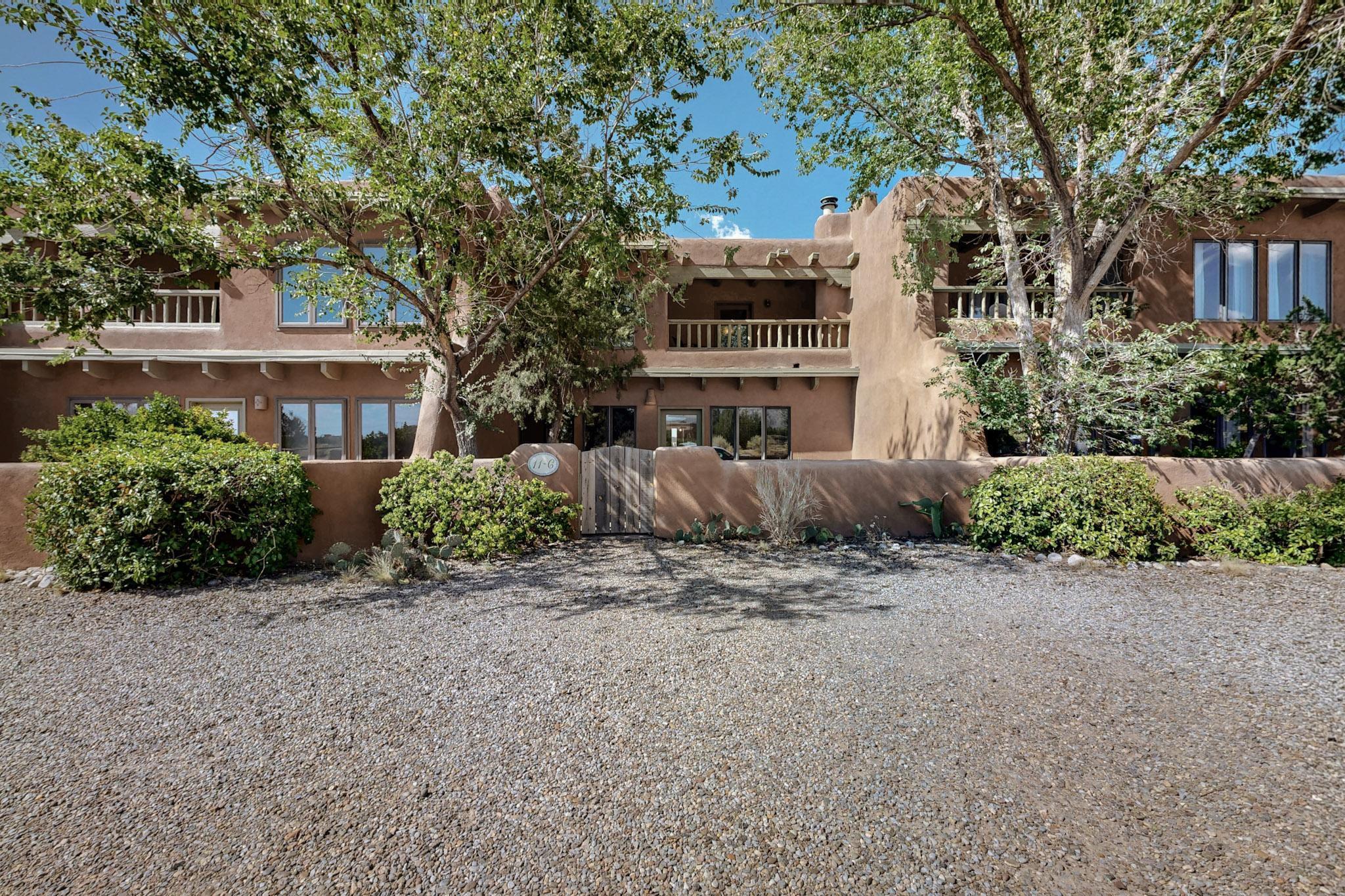 Discover southwestern charm in this delightful Placitas townhome, one of very few and rarely available. This home welcomes you with adobe accent walls and exposed vigas that tell stories of timeless craftsmanship. Traditional New Mexican character featuring hand painted tiles used in the kitchen and baths, viga and wood ceilings, brick floors and a cozy kiva fireplace. Huge primary bedroom with balcony access and Sandia Mountain Views. The kitchen is complete with custom cabinets and stainless steel appliances. Landscaped front and back courtyards.  Conveniently located 2 minutes from I-25. Living in Placitas means embracing the best of Placitas' outdoor lifestyle. The nearby Placitas Trail head offers hiking enthusiasts direct access to scenic trails. Schedule to see it today!