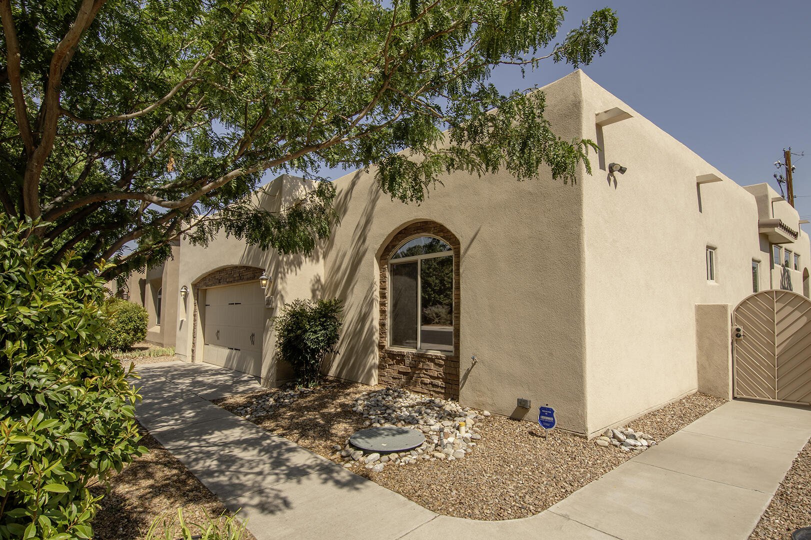 Welcome Home to Candelaria Village! This beautiful gated community in the heart of the North Valley beckons you home to quiet luxury and ease of care in this single story sophisticated patio home. Amenities include NM Gold Standard Green building, custom cabinetry, granite counter tops and stainless appliance package, Broan air purifier system, reverse osmosis water system and smooth plaster Variance in main suite shower and dining room, water proof high performance vinyl plank flooring in the main bedroom and porcelain tile throughout the remainder of the house. Yard is low maintenance SynLawn so you can spend your free time relaxing and not ''yarding'' when you get home. Tinted windows and wood blinds throughout help to keep the summer heat at bay while you