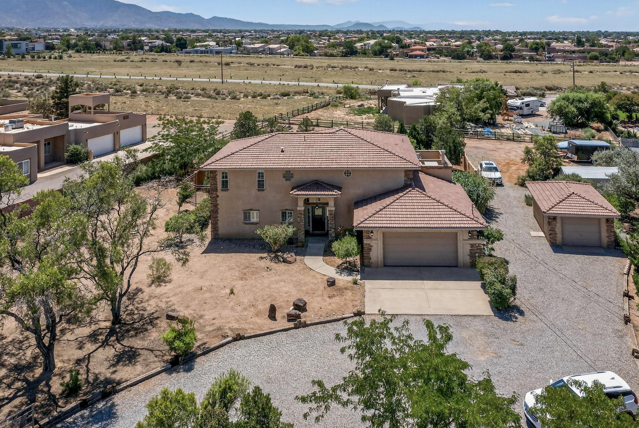 Words can't fully capture this exquisite North Albuquerque Acres estate. Privately gated on a .89-acre lot, it boasts over $100K in premium upgrades and breathtaking mountain, city, and sunset views. Also in October, a full and clear view of the Balloon Fiesta from the home! Inside, 4 bedrooms plus an office, 4 baths, and a lavish primary suite with private balcony offer elegance at every turn. New tile floors, plantation shutters, and a brand-new gourmet kitchen with granite, custom cabinetry, and top-tier appliances elevate daily living. The great room dazzles with a fireplace, wet/coffee bar, and refined soffit details. Outdoors, enjoy a sparkling pool, multiple covered patios, and ample entertaining space. Oversized 2-car garage plus detached 1-car. Near top-rated schools.
