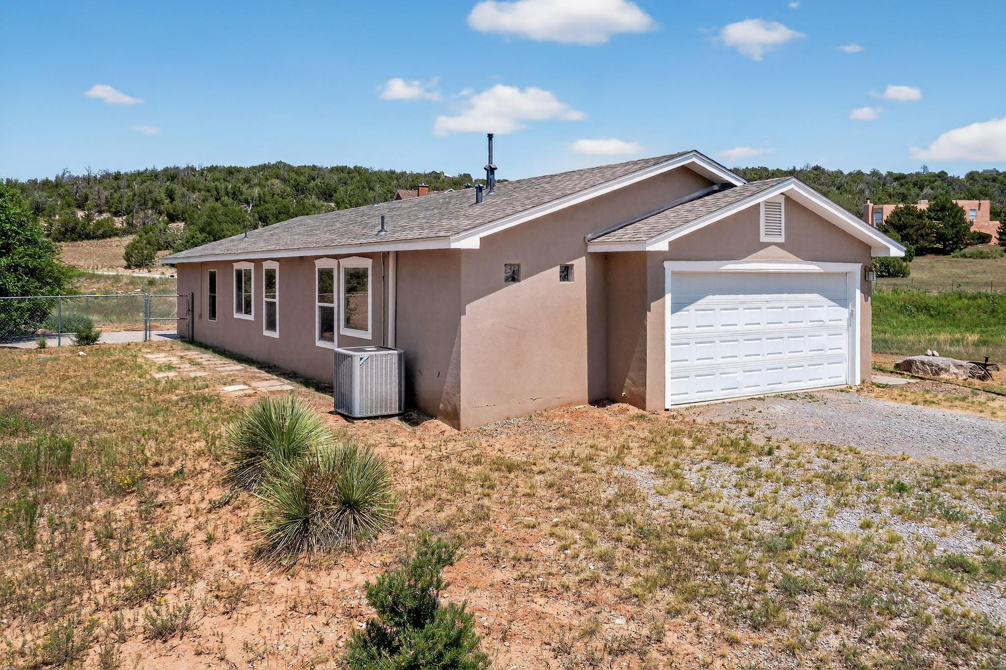 Welcome to 154 Thunder Mountain Rd, your peaceful retreat in Edgewood, NM. This 3-bed, 2-bath home on 2 lovely acres offers stunning views of the Sandia Mountains and room to roam. Relax on the back porch and watch breathtaking sunsets or cozy up by the gas-fired stove inside. The open layout features vaulted ceilings and a sunlit kitchen with ample counter space, perfect for cooking and gathering. The primary suite offers a private escape with an en-suite bath. Enjoy an attached, 2-car garage, room for boat/RV parking, and space for animals, gardening, or hobbies. Whether you're unwinding or homesteading, this property blends comfort, beauty, and functionality in a serene setting just minutes from town. Schedule your showing today!