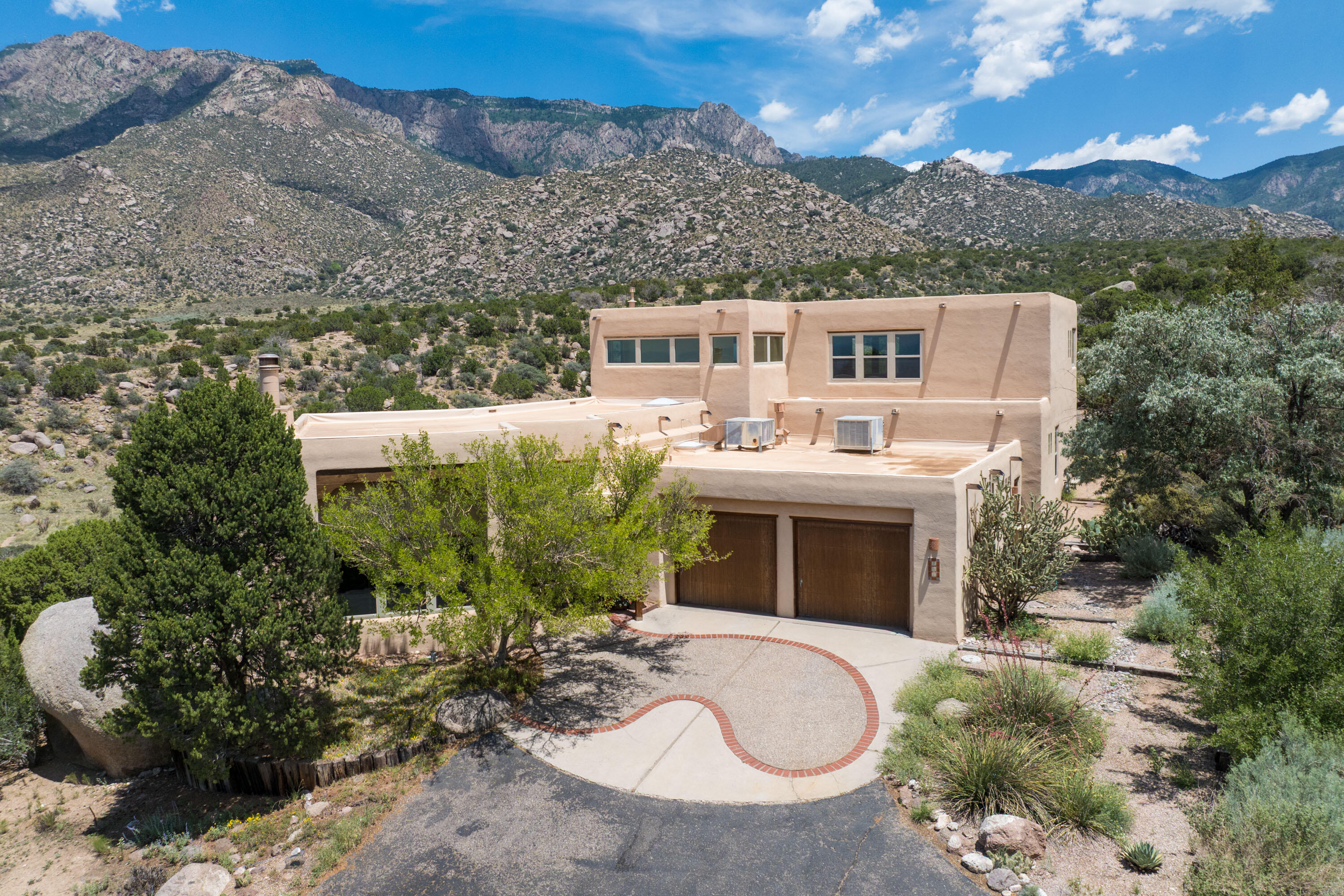 Custom Omega Builders, 4 bdrm, 4 bth home that backs up to the National Forest in SANDIA HEIGHTS with amazing mountain & city Views! Step inside this light & bright home and enjoy the living and formal dining area, perfect for entertaining or gathering by the custom wood burning fireplace. Multiple large windows throughout flood the space with natural light. The kitchen is complete/w granite countertops, kitchen island, Ernie Torres cabinets & direct access to an outdoor patio--perfect for enjoying morning coffee or evening sunsets. The primary suite offers a peaceful retreat with sweeping city VIEWS & generous space. Large secondary bedrooms provide comfort and privacy, perfect for families/guests. 1+ acre lot. Easy access to trails & open space.
