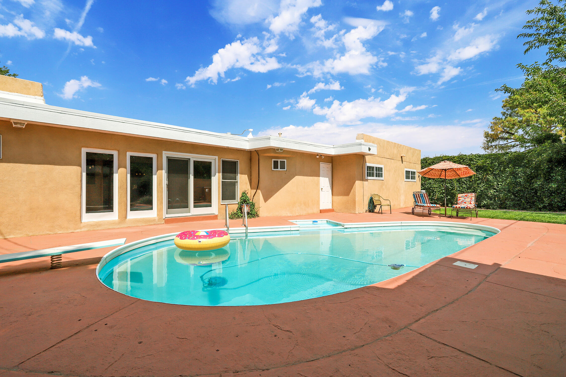$25K Price Improvement! Now $750K! OPEN Fri 9/5 3-5 PM, Sat 9/6 12-2 PM, & Sun 9/7 11-1PM. Escape the ordinary and discover a private oasis in the heart of Albuquerque's desirable UNM/Altura Park area. This beautifully updated home offers a serene retreat where the outside world fades away the moment you step inside. Entertain outdoors on your covered courtyard patio with an enchanting fountain and walled privacy to enjoy the crisp New Mexico evenings. Open and inviting living spaces welcome you, featuring a stunning, gourmet kitchen that's a chef's dream!  It's equipped with a spacious island, gas range, undermount sinks, under cabinet lighting, and an abundance of storage for all your culinary needs. The kitchen seamlessly flows into the dining room and large family room,