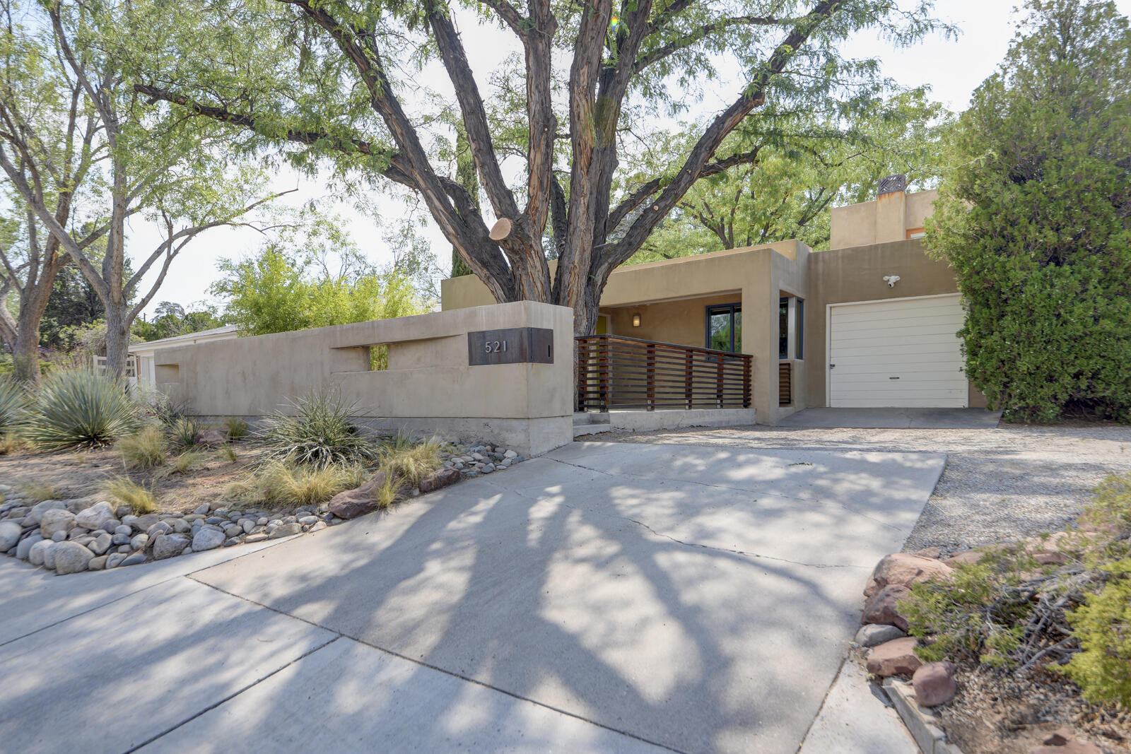 Custom designed addition combined with original charm is seamlessly brought together by well-known local architect Mark Baker. Enjoy the sunrise and ''magic hour'' over the Sandias from the strategically placed deck in the front courtyard. The stairs to the primary feature custom iron railing and color. Install a rooftop deck for an even better view from the rooftop access! Original wood floors in the front, modern kitchen with tons of natural light, and a custom fireplace in the second living area all make for a serene and cohesive floorplan. A built-in desk area off the kitchen adds to the architectural interest while offering a highly functional space for home office, pantry or laundry folding station. The ''garage'' is great for bike storage. All this and the roof is only 5 years old!