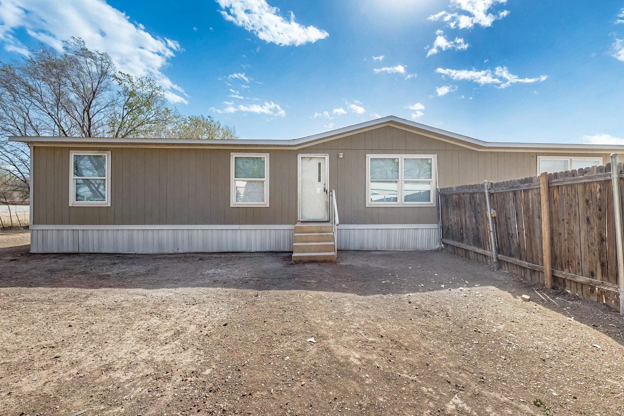 This charming 2019 double-wide manufactured home in the heart of Bernalillo is move-in ready with thoughtful updates throughout. Inside, you'll enjoy fresh paint, new flooring, modern blinds, updated toilets, and a brand-new stainless steel gas stove. Refrigerated air keeps the home comfortable during these hot summer days. Connected to city water, public sewer, and public utilities, it's ready for easy living. Outside, the spacious backyard is enhanced with pine trees and rose bushes, offering both shade and beauty, along with a shed for extra storage.