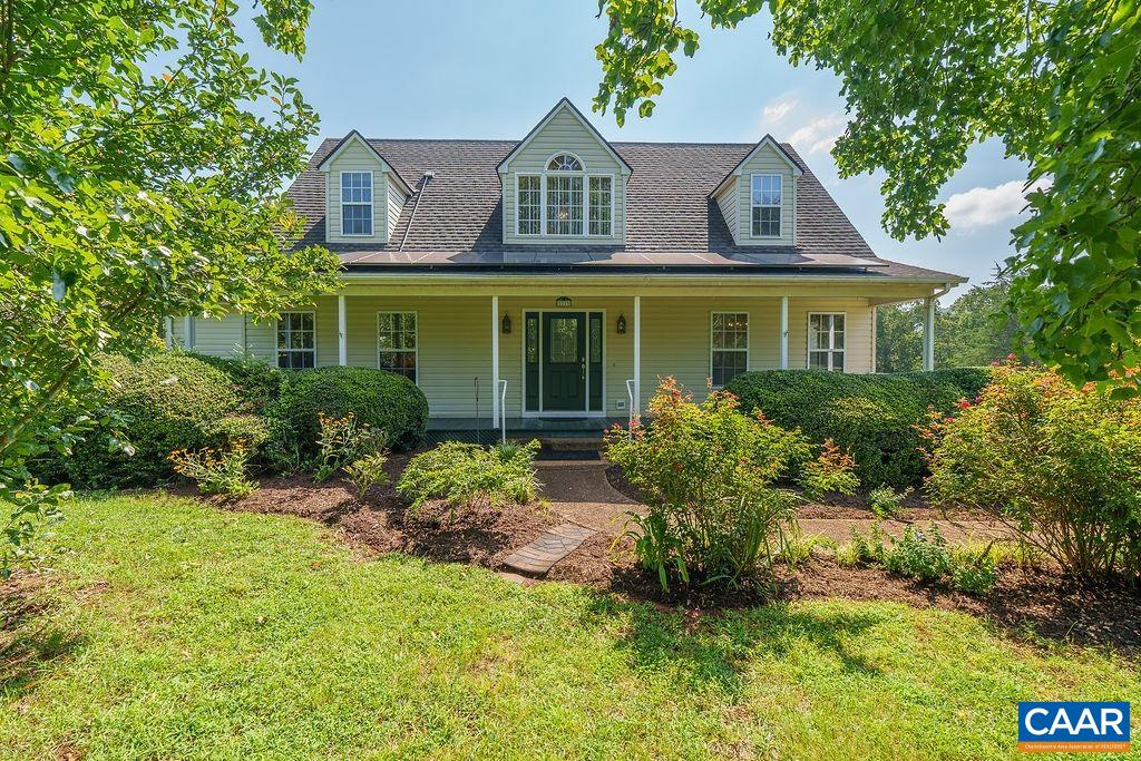 Experience the perfect blend of country charm and modern convenience in this beautifully maintained home, located just a short drive from Charlottesville. Enjoy peace and privacy on a large open lot featuring a partially fenced backyard,  blackberry bushes, asparagus, Paw Paw native plants, and even a Persimmon tree.  Step inside to find a spacious and inviting layout with hardwood floors, a cozy gas log fireplace, and dual heating. The home boasts new appliances and solar power, keeping your electric bills impressively low — averaging just $8/month!  Relax on the large back deck or covered front porch and take in the serene surroundings. The main level features a primary bedroom suite, an additional bedroom, and easy everyday living. Upstairs offers two more bedrooms, a full bath, a bonus room, and ample storage with walk-in attic spaces off each bedroom. Additional highlights include:  2-car garage, Paved driveway,  Full unfinished basement ready for expansion or storage, Spacious backyard with mature landscaping and an established garden space.  This home truly offers the best of both worlds — comfort, sustainability, and space — all in a tranquil country setting. Schedule your appointment today!