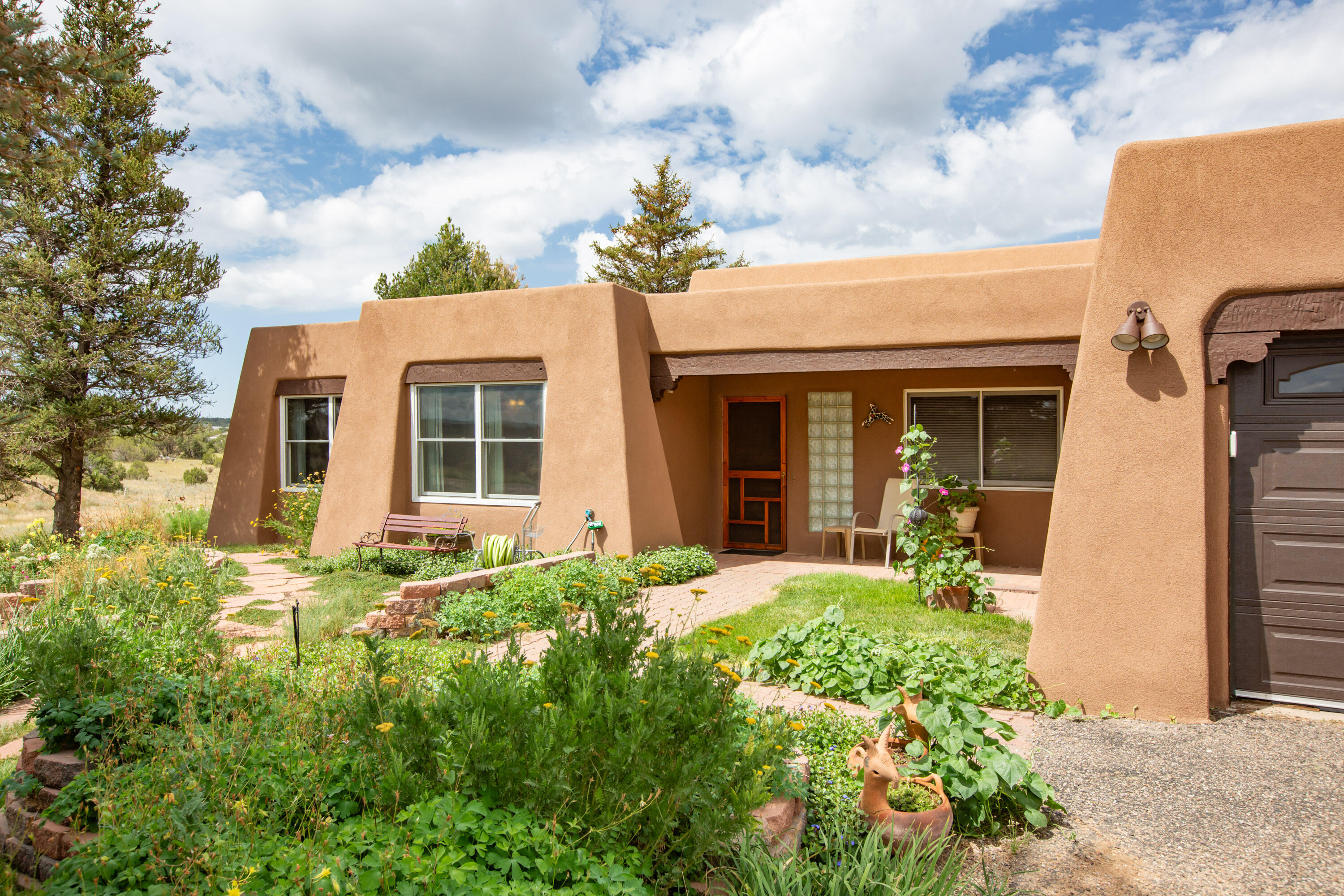 Open Sat/Sun 2-4pm. Don't miss this lovely single-level southwestern home situated on 2.5 lush acres in the East Mountains. Enjoy dining al fresco or from the lovely dining area, both w/incredible Mountain views.  Enjoy your favorite cup of coffee or tea, read a book or talk with friends in the lovely sunroom.  The heart of the home is a Great Room w/cathedral ceiling, abundant natural light, toasty Kiva fireplace, wonderful sitting areas and so much more. Spacious master suite with Sandia mountain views and a fabulous updated bath with electric fireplace and  walk-in closet.  2 other large bedrooms.  An updated Kitchen has lots of counter area, plentiful cabinets, pantry and is open to Living area. Lush landscaping for the garden lovers. Very usable 2.5 acres. Private dead-end street.