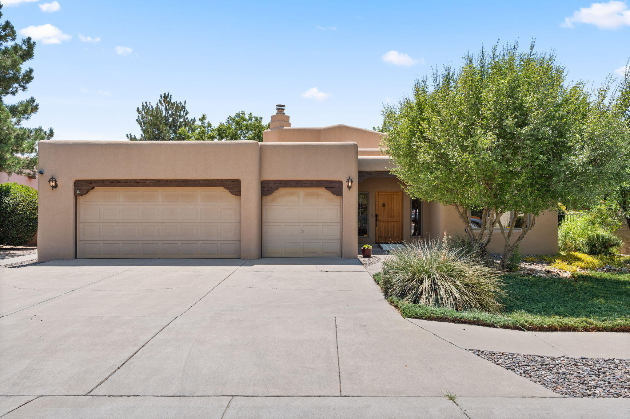 OWNED SOLAR! Step into timeless New Mexico style in this 3-bedroom, 3-bath North Valley home where raised ceilings with exposed beams and skylights create a warm, airy feel. The spacious kitchen is a chef's dream with a large island, range hood, double ovens, and abundant cabinetry. The great room features a kiva fireplace, while a second kiva graces an additional bedroom or living area. Enjoy zoned refrigerated air with mini-split, radiant heat, and a 2018 TPO roof. Outdoors, relax under large covered patios. The 3-car garage offers a workbench and storage. With easement access to trails through Thomas Village, La Montanita Co-op nearby, downtown just minutes away, and the airport a short 10-minute drive, this home blends charm, comfort, and convenience.