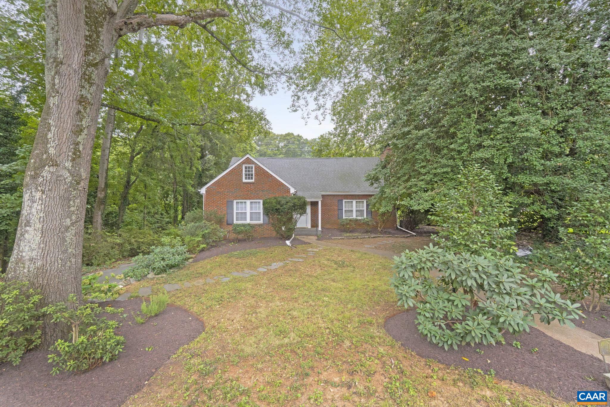 Charming and solidly built 1950s brick home on a spacious 0.5-acre lot in a prime Charlottesville location. Hardwood floors run throughout the main level and continue into a thoughtfully designed half-story addition featuring a modern primary suite with walk-in closet and a spacious en suite bath—complete with soaking tub, dual vanities, and tiled shower. The main level includes three additional bedrooms, one of which was the original primary with its own attached bath. The living room offers a decorative fireplace ready for a gas insert framed by custom built-ins and the kitchen has new porcelain tile and walks out to a side porch. The finished basement features a wood-burning fireplace, full height windows, and new LVP flooring, adding flexibility for recreation or work-from-home space. Recent updates include roof (2021), HVAC coil (2020), tankless gas water heater (2012), garage/basement windows (2012). LEAP Certified