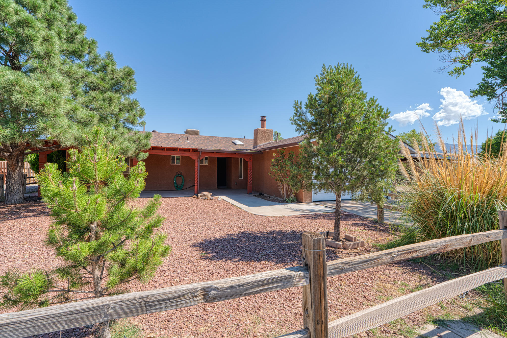 North Valley Living - Town Close, Country Fresh! Welcoming ranch-style home on a spacious 1/2-acre lot. Enjoy lazy afternoons on the covered front porch, perfect for rocking chairs and a dozing dog. Car lovers will swoon: attached 2-car garage, front 2-bay carport, and a detached 2-car garage, plus RV space and waste station. Room to add an ADU, garden, or keep animals. Inside offers 3 generous bedrooms, 2 baths, a spacious great room, formal and casual dining areas, and a heated/cooled enclosed sun porch. Updated primary bath is mobility-friendly. Modern touches throughout: tile floors throughout (no carpet), some fresh paint, skylights and updated fixtures. Backyard vehicle access on both sides. A versatile property that offers space, comfort, and flexibility, come see the possibilities!