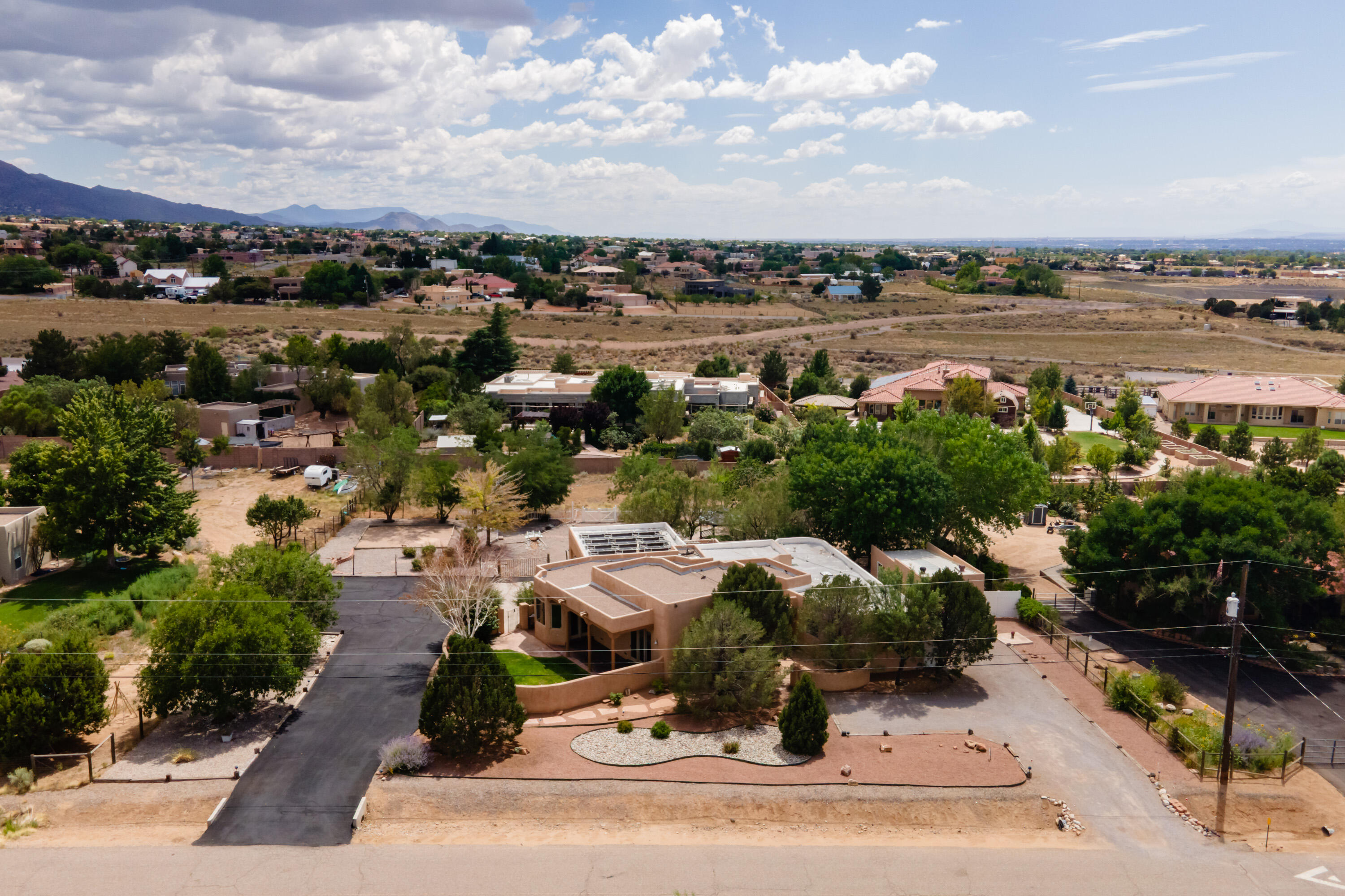 Move In Ready One Story Custom Home Located in North Albuquerque Acres! Nestled on a sprawling .89-acre lot, this beautiful one-story custom home has Sandia Mt views & offers the perfect blend of modern efficiency and enchanting New Mexico charm! With approx 2,700SF of thoughtfully designed living space it includes 4BR's, 3BA's & 4 Garage spaces!  Features: Owned Solar installed in 2022, Beam Ceiling & Carved Posts, Kiva FP, Private Well, Radiant Floor Heat, Wood Flooring, Slate Tile, Pella Windows & Doors, entire home  professionally painted & cleaned! Located near excellent schools & shopping!  The long-time owners have poured love and care into every inch of this home, ensuring it's ready for its next fortunate residents. Don't miss your chance to own this remarkable property! More