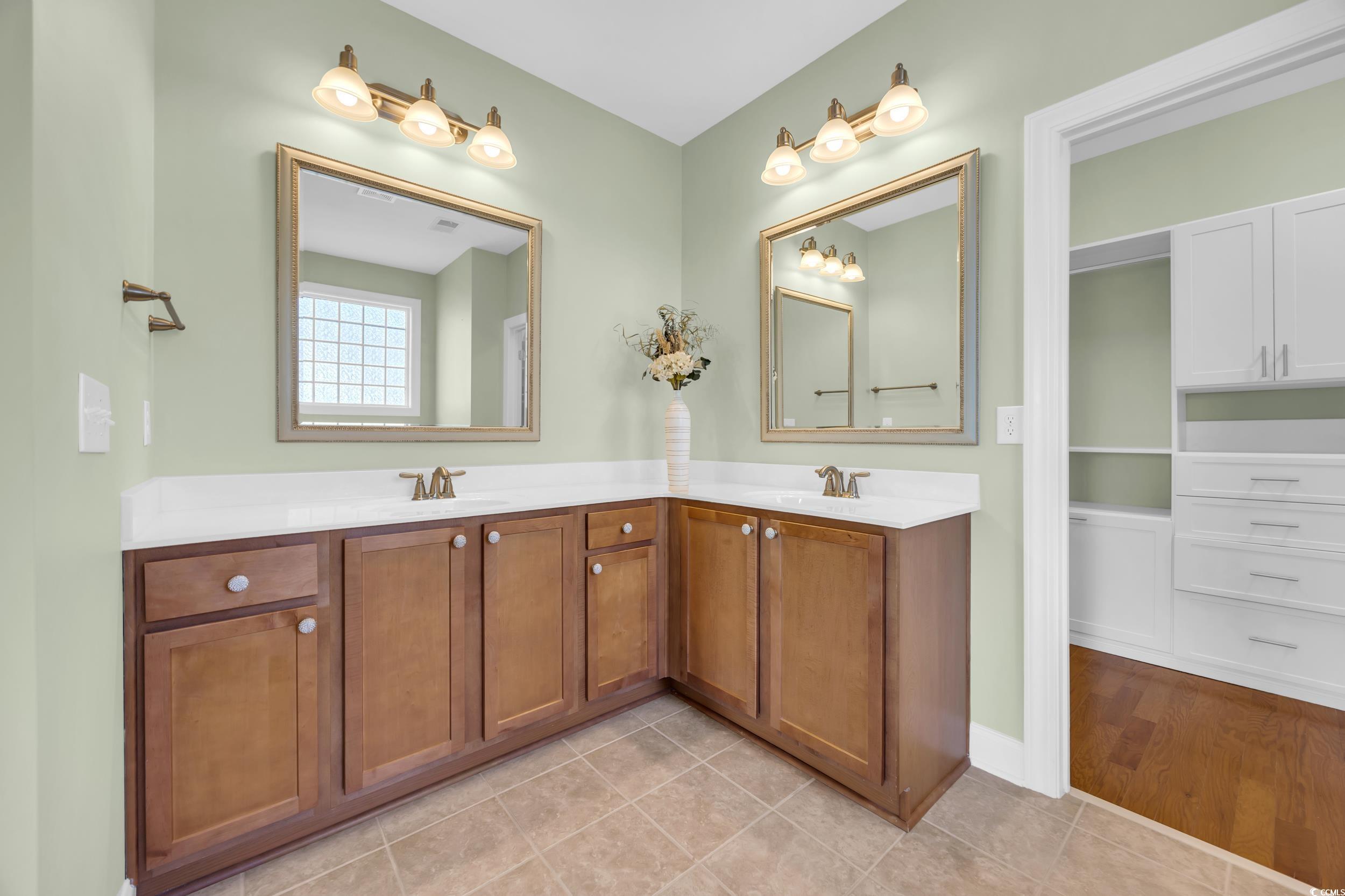 Bathroom featuring double vanity and light tile patterned flooring