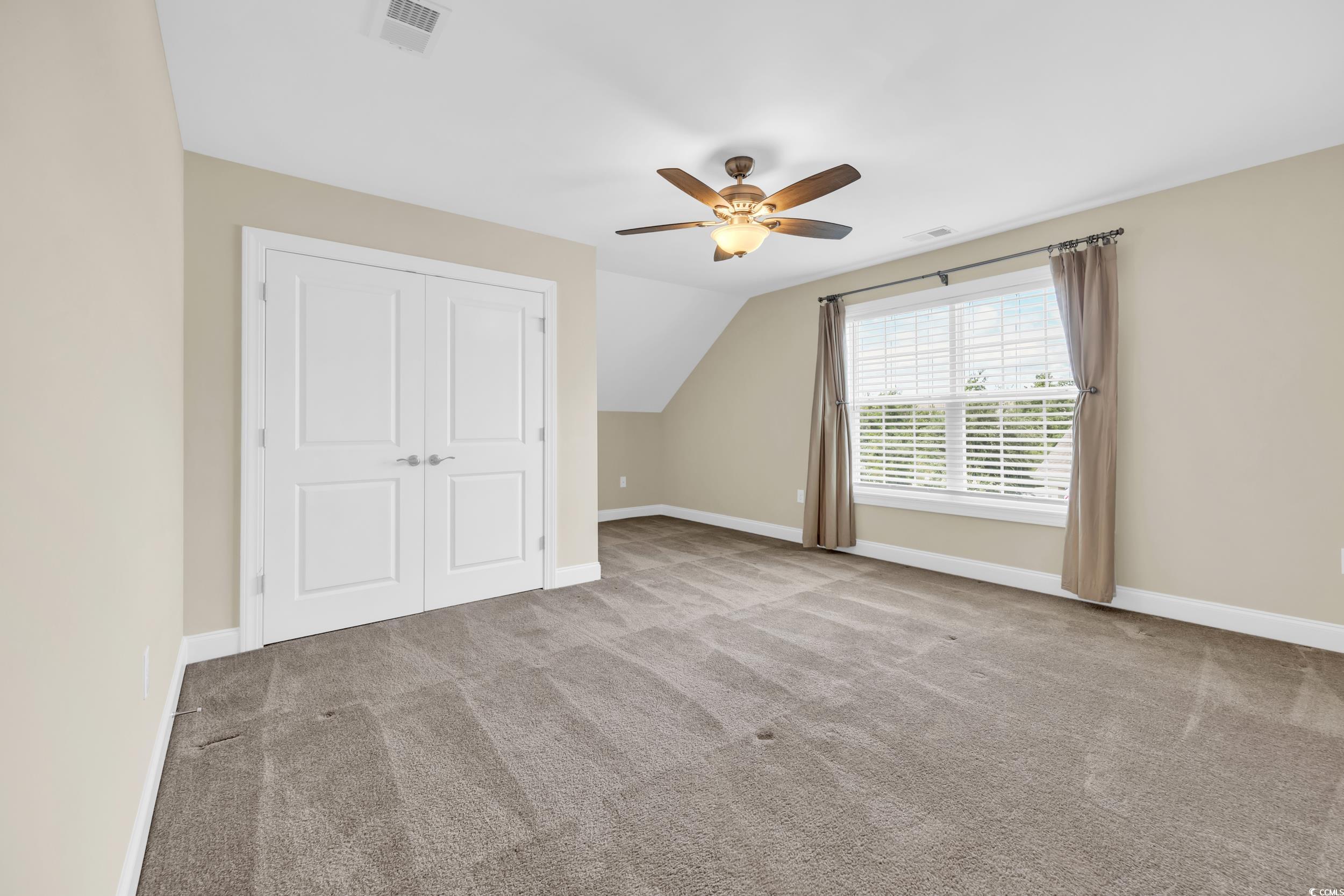 Bonus room with carpet floors, vaulted ceiling, and ceiling fan