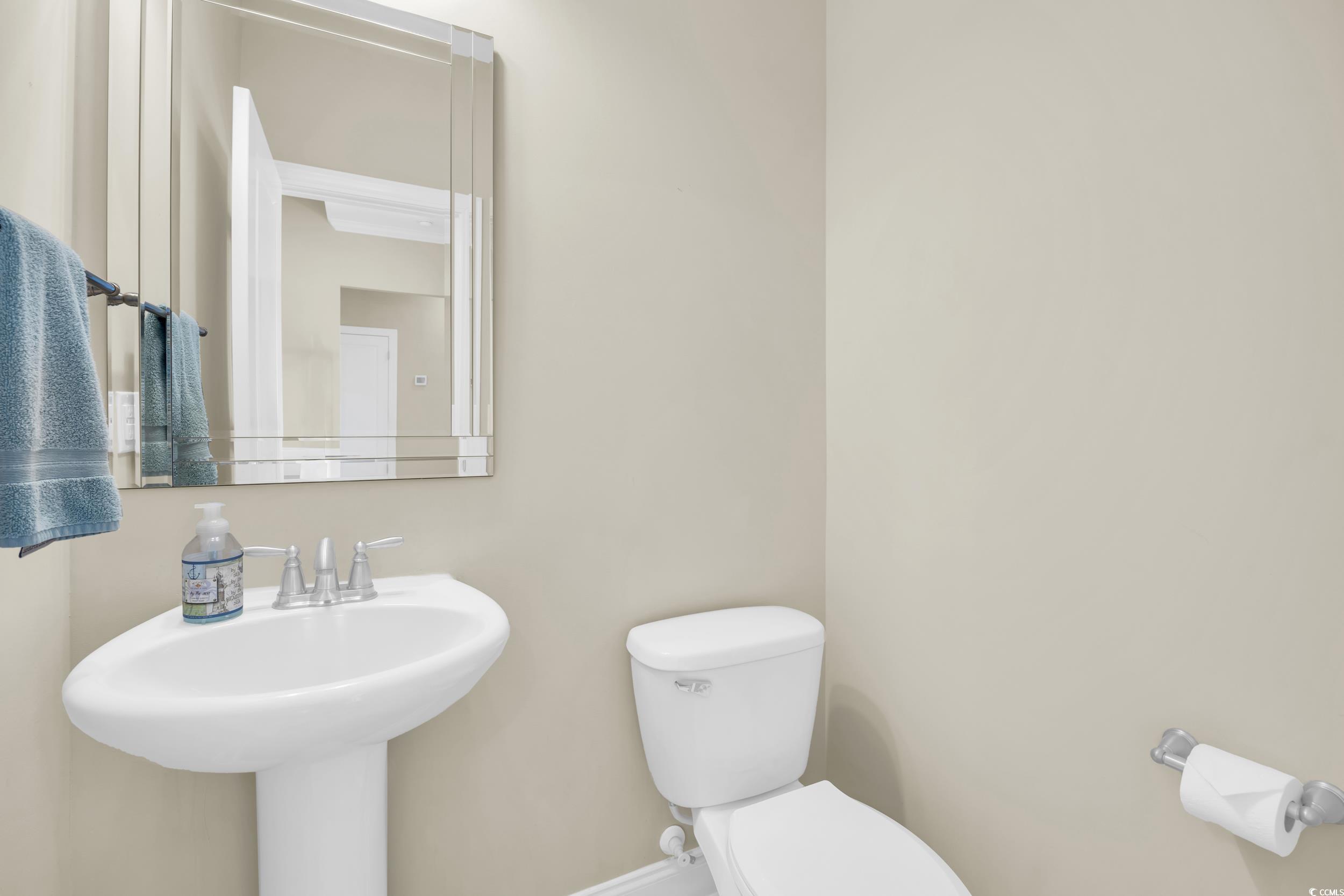 Half bathroom featuring toilet and baseboards