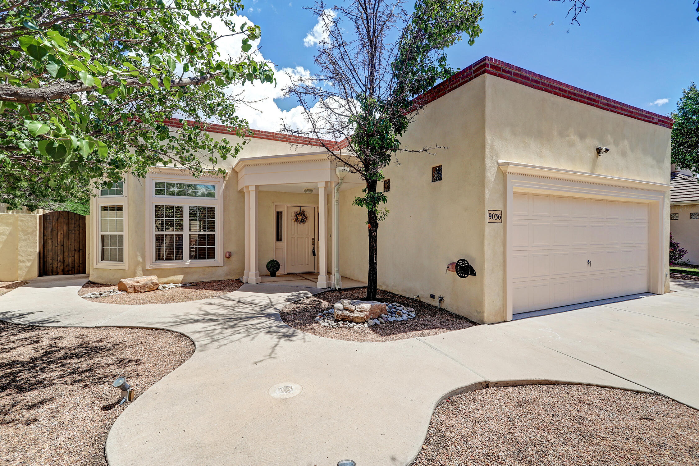 Discover this wonderful one-level Territorial-style home that blends charm, comfort, & accessibility.  Thoughtfully designed with ADA compliance, it features wide hallways & large doors throughout.  Inside, soaring ceilings & abundant natural light create an inviting atmosphere. A formal dining room & other eating space flows seamlessly into the great room, complete with a cozy gas-log fireplace.  The large primary suite offers a luxurious bath w/ a garden tub, roll in shower, & dual sinks.  2 walk-in closets & a door to the back yard. Nice sized secondary bedroom & the 3rd bedroom would make a wonderful study w/ its built in book shelves. Out doors, enjoy the serene backyard with its beautiful waterfall feature & easy care landscape perfect for relaxation  or entertaining.