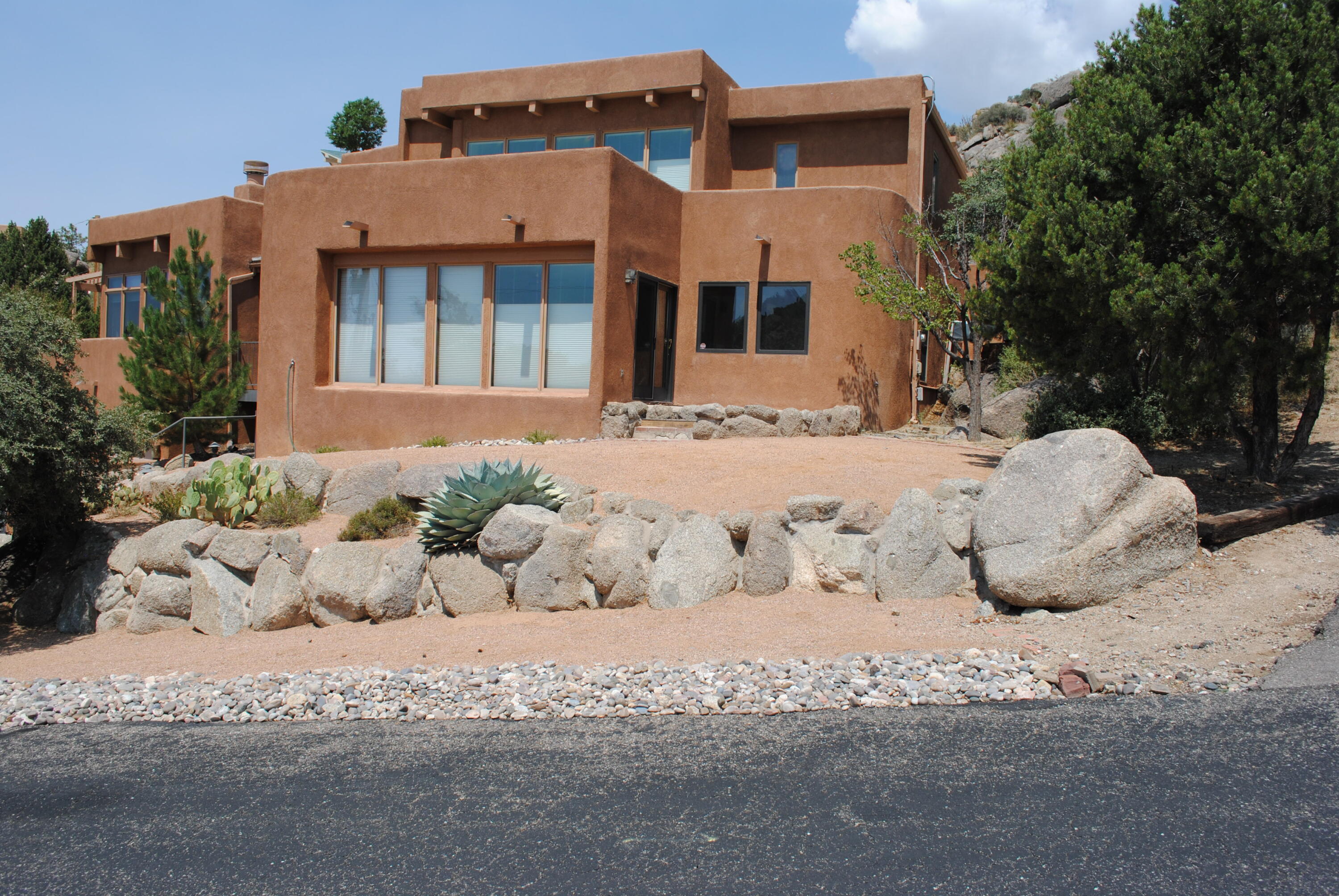 Live among the boulders, high above the city. Custom home with a private drive in Glenwood Hills. Multi level home that takes advantage of the lot elevations. The master bedroom is alone at the top. Custom pedestal bed with built in storage, fireplace and wet bar highlight the room. Access your private balcony and enjoy city and foothill views. Main level has 3 bedrooms, 1 with its own bathroom and private patio, the other two have a shared bath. Large utility room with folding counter and great storage. The living room with stacked stone fireplace, a sunken bar area, adobe accent wall and access to side and back decks complete the main level. Step up to the kitchen and dining areas that overlook the living room. Step through to the family room designed for privacy or entertaining.