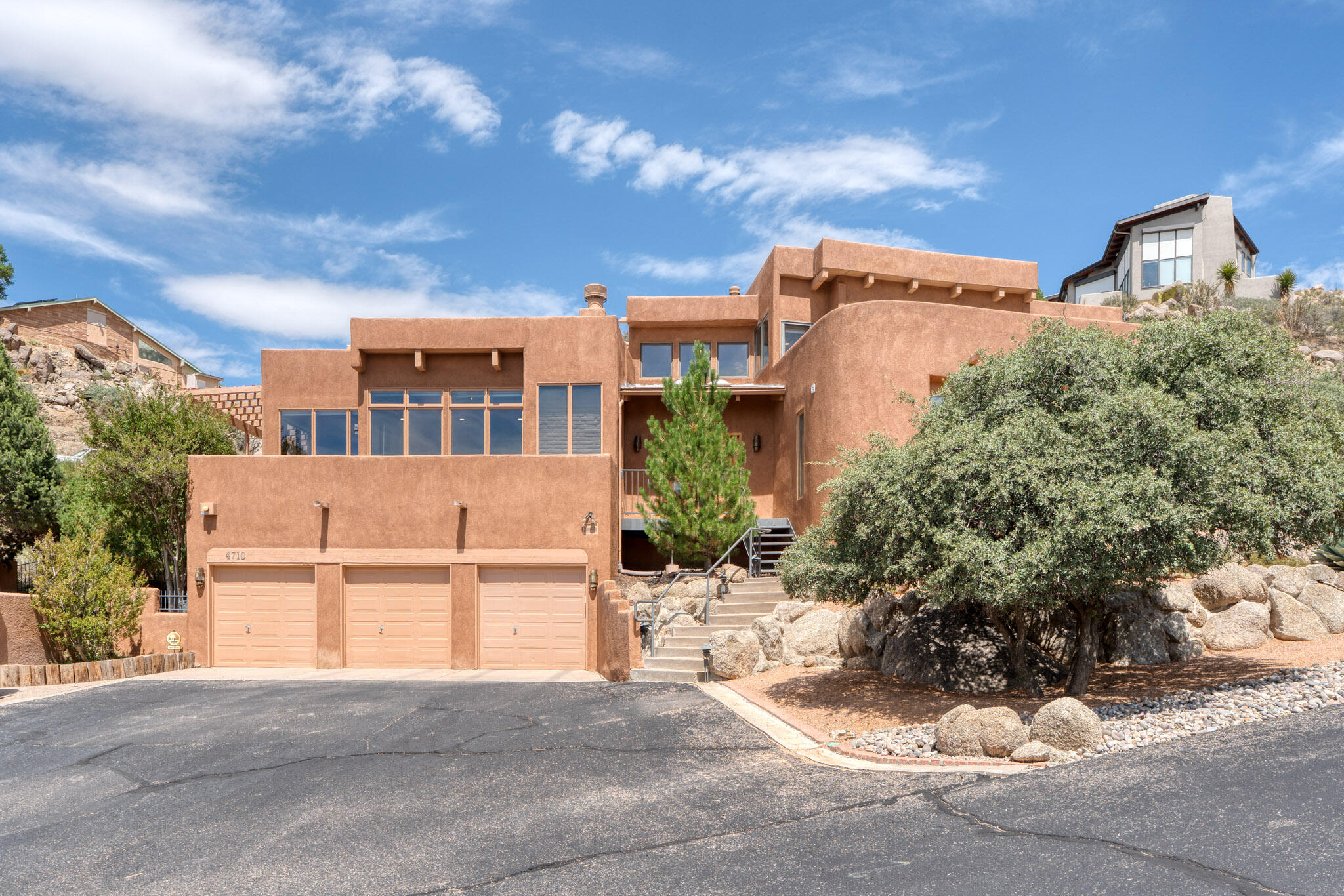 Well designed, custom home with panoramic city and mountain views on a private drive just steps away from the open space. Passive solar design provides warmth and efficiency using adobe trombe walls for heat collection & storage. High, tongue & groove ceilings are featured throughout. The main floor has a large, open living area/kitchen/dining room and a sunken bar that is perfect for entertaining or family gatherings. A second den adds more entertainment space. This floor also features a large bedroom with its own bathroom and walk-in closet. Two additional bedrooms share a Jack & Jill bathroom. The primary suite, with private deck, occupies the second floor. Multiple decks offer mountain and city views! A custom gunite hot tub built into the rocks provides relaxation and mountain views.