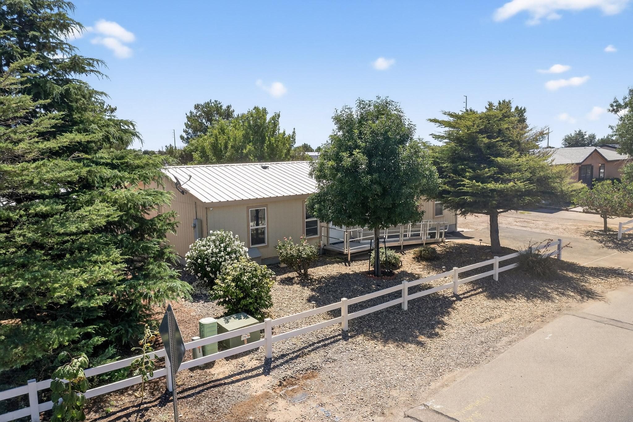 Take in breathtaking city and mountain views from the spacious viewing deck of this meticulously maintained manufactured home. The updated interior features easy-care hard surface floors throughout, with no carpet, and a private primary suite thoughtfully separated from the additional bedrooms. Situated on a generous 1/2-acre lot, there's plenty of space for hobbies, toys, or outdoor entertaining, all while enjoying unobstructed vistas. Built on a permanent foundation with a durable metal roof, this home reflects exceptional care and pride of ownership. Additional highlights include low-maintenance landscaping, a fully fenced double yard, and a storage shed. Clean, move-in ready, and inviting, this home offers comfort, convenience, and lasting value--an absolute must-see!