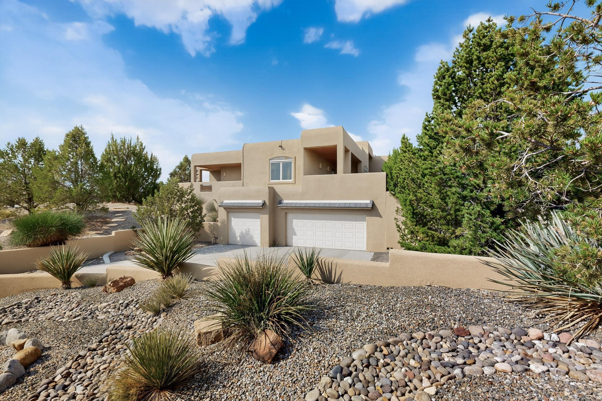 Classic Southwestern home in Placitas with 4,322 sq ft, 4 bedrooms, and 3 baths. High, open ceilings and large windows fill the home with light and frame mountain views. The living room features a double-sided fireplace shared with the primary suite. Two bedrooms open to covered patios, including a private en-suite that features its own incredible views The kitchen connects to the dining and living areas, creating a warm central gathering space. A finished, heated lower-level game room offers flexibility for a theater, gym, or studio. Wraparound composite decks with tongue-and-groove ceilings invite year-round outdoor living. Recent updates include newer roof, stucco, AC units, and reverse osmosis system. An oversized 3-car garage provides convenience and storage.