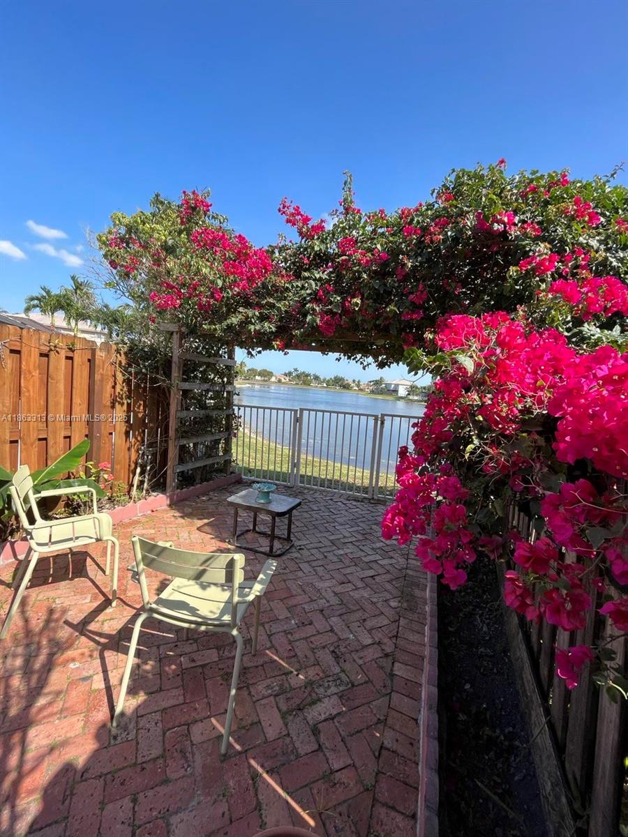 Welcome to this stunning home in the GATED COMMUNITY of Melrose Landing II. Tucked away on a quiet street, this home offers both privacy and peace of mind in a neighborhood known for its safety & low HOA dues. (ONE OF THE LOWEST IN THE AREA!) From the moment you step inside, you'll feel the warm & family vibe you're looking for. W/CHERRY-WOOD floors, the kitchen has an open layout that flows seamlessly into the living area, great for making memories. Step outside & enjoy the porch along with the paver patio perfect for gatherings & the breathtaking WATER VIEW of the COMMUNITY LAKE, where relaxing mornings or peaceful evenings can be found in your own BACKYARD. This home comes with a Carico water filtration system, a convenient AC split in the garage, & Electric roll down shutters for patio