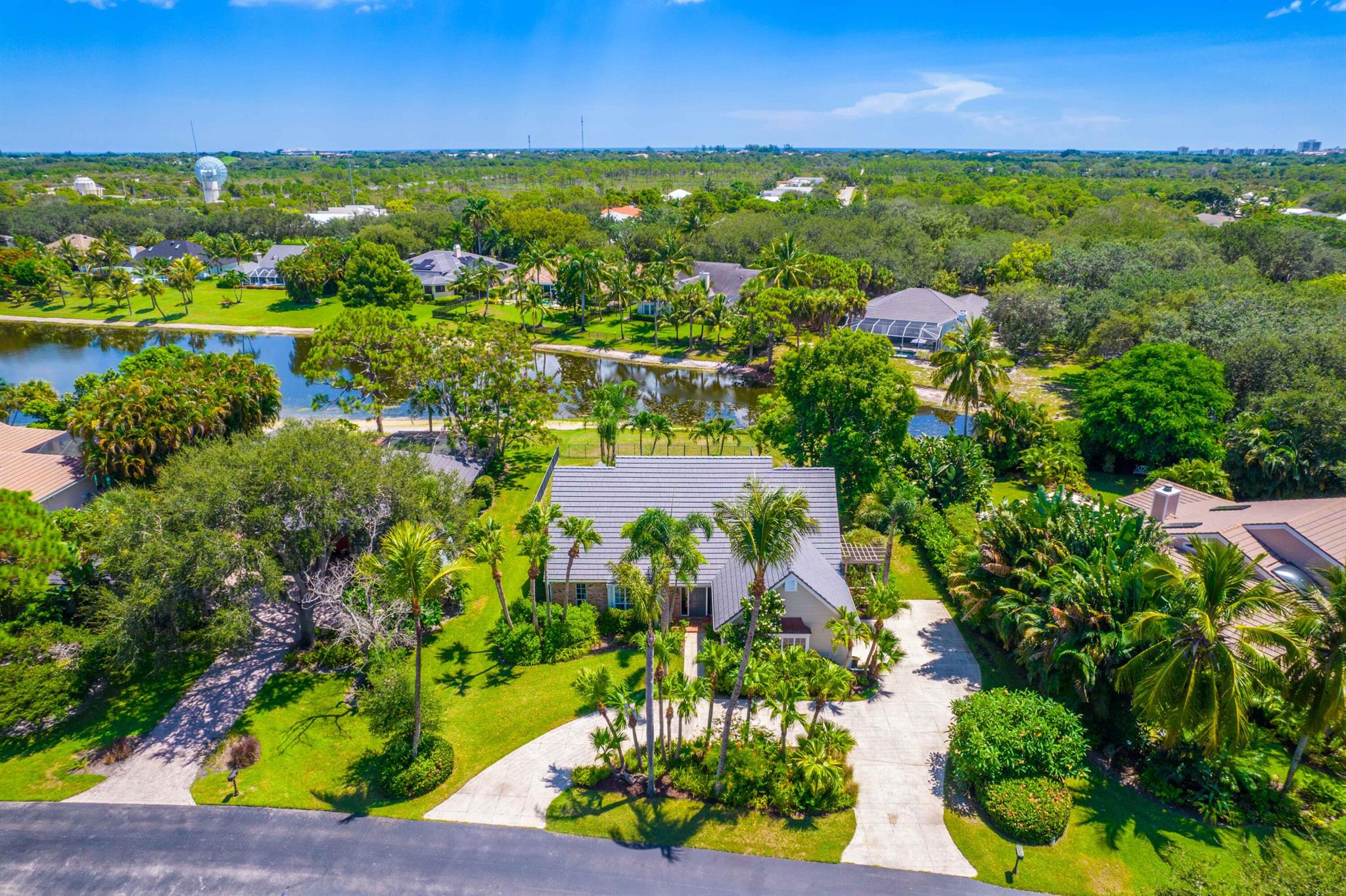 Nestled in the picturesque, tree-lined community of River Ridge, this inviting home blends comfort, style, and convenience. Set on a peaceful lake and just minutes from the beach, it offers a relaxed Florida lifestyle in a private, gated setting. Brand new 2025 Roof. The primary suite is located on the main floor and features plantation shutters, a large walk-in closet plus a built-in closet, and a spacious master bath. It also connects to a versatile flex room that works perfectly as an office, nursery, or guest space. The living room is filled with natural light with soaring ceilings, creating an open, welcoming atmosphere for everyday living or entertaining. Sliding doors lead to the covered patio and pool area--an ideal spot for sunsets and entertaining. SEE MORE... The kitchen combines beauty and function with white shaker cabinetry, warm wood floors, soft coastal tones, and eye-catching pendant lighting. Designed for gatherings big or small, it flows easily into the dining and living spaces. Upstairs, you'll find two comfortable bedrooms, a stylish bathroom, and a central loft that can serve as a TV room, playroom, or lounge. Throughout the home, thoughtful details such as solid wood doors, trim work, and plenty of built-in storage show the attention to quality. Additional highlights include a breakfast nook, half bath, formal dining room, and an attached two-car garage. River Ridge residents also enjoy 24-hour gated security, a clubhouse, tennis courts, and a playground, all in a community known for its natural beauty and charm.