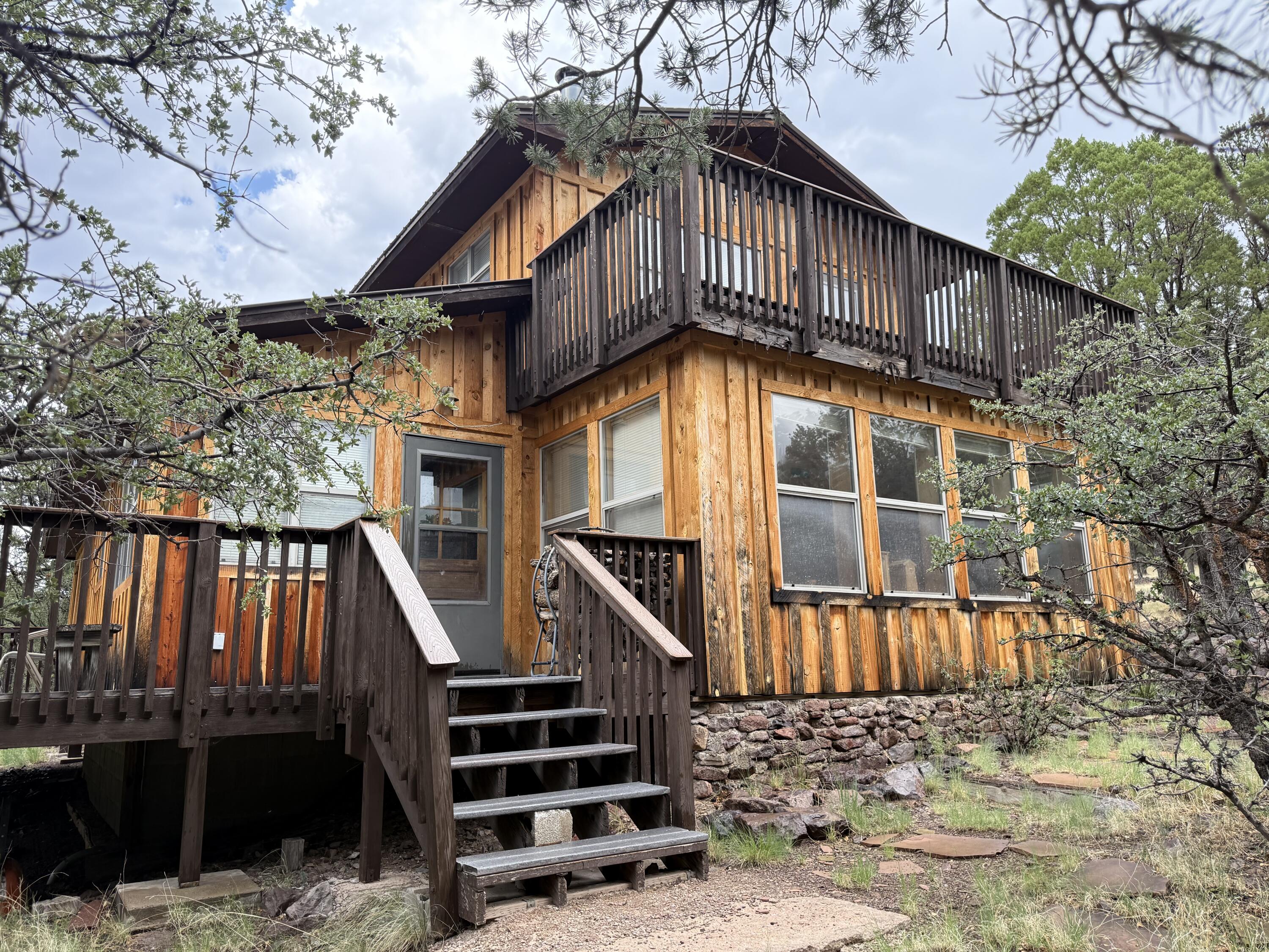 Escape to tranquility in this stunning 1,454 SF custom-built 2-story cabin nestled in Hop Canyon, just minutes from the charming village of Magdalena. Surrounded by 4.83 acres of pristine land with majestic mountain views, this turnkey retreat features tile and wood flooring, a durable metal roof, and a spacious top deck perfect for stargazing under New Mexico's famously dark skies. Mature pinon, alligator juniper, and cedar trees frame the property, attracting abundant wildlife and offering unmatched privacy. Whether you're seeking a peaceful getaway or a full-time residence, this cabin delivers rustic charm and modern comfort. Call the listing broker today to schedule your private tour!
