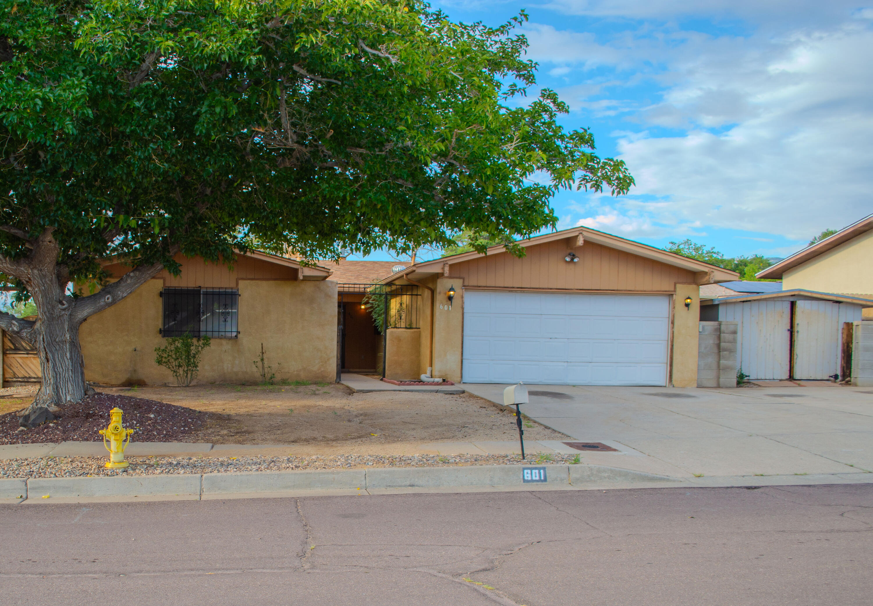 This charming corner-lot home offers the best of NE Heights living--just minutes from Kirtland Air Force Base, with mountain trails and city conveniences close by. A sunny eat-in kitchen with wall-to-wall cabinets, a spacious backyard and garden set the stage for everyday comfort. With a 2-car garage, extra parking, and two outdoor storage units, there's plenty of room for all your needs. Perfect as a first home or ready for you to add your personal touch, this property combines location, space, and potential in one inviting package.