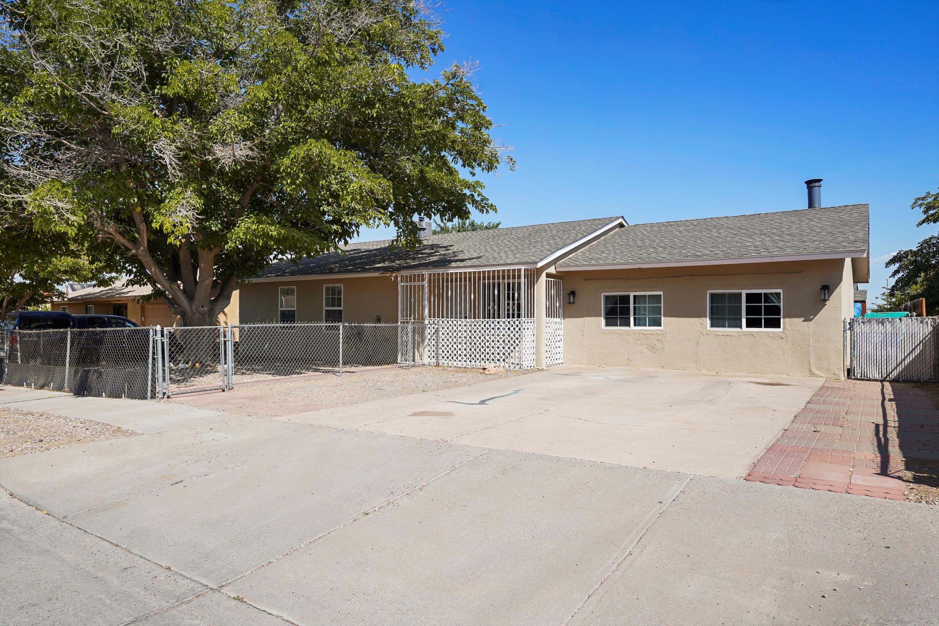 WELCOME TO A HOME THAT EMBRACES SPACE, COMFORT, AND CONVENIENCE. Nestled in a well-established Albuquerque neighborhood close to schools, parks, shopping, and easy I-40 access, this 5-bedroom, 2-bath residence offers room for everyone. Inside, modern wood-look flooring flows through a spacious living room, separate dining area, and a large private kitchen with bar seating perfect for gatherings. The well-kept home boasts security bar windows for peace of mind, while outside you'll discover a very large fenced backyard with grass, a combo patio, storage, and a shade-giving tree out front. Don't miss your chance to make 10400 Benavides Road SW your own! Schedule a showing today.