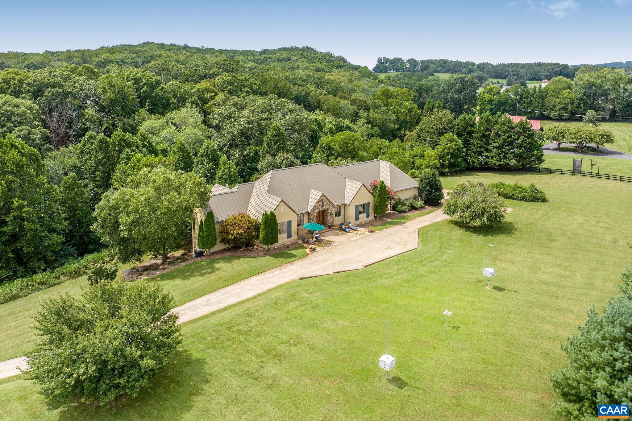 Set on nearly 4 peaceful, gated acres just minutes from town, Keswick, local vineyards, and renowned restaurants, this private retreat is designed for effortless main-level living. The heart of the home is the stunning, renovated chef’s kitchen, featuring double islands, abundant cabinetry, luxury appliances, beverage drawers, and thoughtful details throughout—ideal for gathering and entertaining. The kitchen opens to a light-filled family room with a stone fireplace and access to the serene back deck and screened porch, perfect for taking in the quiet natural setting. The main-level primary suite is a true sanctuary, boasting a spa-like bathroom with a freestanding tub, a custom enclosed shower/steam room and full size stackable washer/dryer. Two additional bedrooms, two full baths, and a spacious mud/laundry room complete the main level. A three-car garage adds convenience. The walk-out lower level includes a living area and flex space with built-ins, a private guest suite with full bath, a fitness area, and a second kitchen area, perfect for multigenerational living or long-term guests. Ample unfinished storage space and a 4th garage bay provide plenty of storage. Purchasers eligible for a 25% discount to the Club at Glenmore.