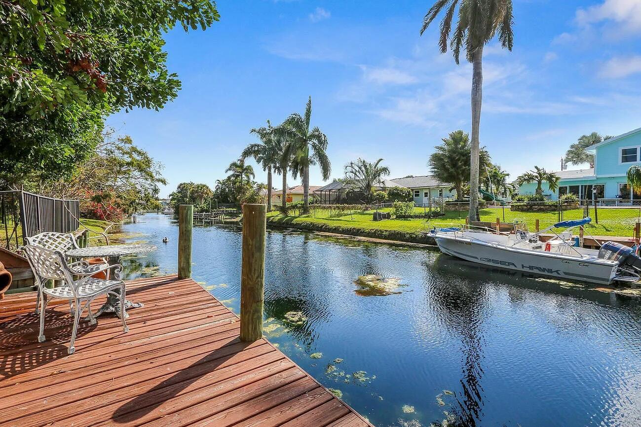 Discover paradise in this 4BR/2BA waterfront home on a peaceful canal in Juno Beach! Enjoy the ultimate Florida lifestyle with a private dock (boat clearance is approx. 4-6'' based on tide) for fishing & paddle boarding right from your backyard. Just a mile to the beach and minutes to shopping, dining, and nightlife, this location blends tranquility with convenience. Inside, find spacious living areas, with open floor plan, and water views to the south. The 2-car garage offers ample storage. Outdoors, relax on the covered porch or unwind in your high-profile pool screen enclosure with a tropical free flow pool & Grato waterfall & large outdoor lanai built-in barbecue overlooking pool with gated aluminum fencing. Step down into Pool deck (which is built 2 feet below ground for privacy)