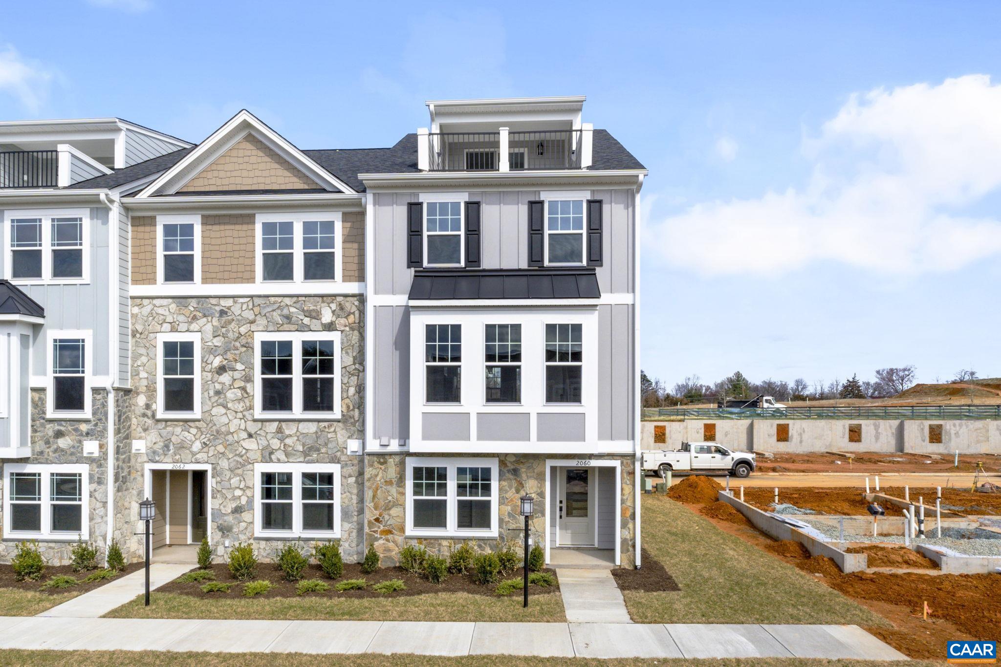 Under construction for an early Fall move-in, the Poplar II townhome is located in Glenbrook, where scenic Blue Ridge Mountain views meet neighborhood parks and trails. This end unit offers farmhouse-style architecture with stone accents and a modern floor plan across four levels. The main living area highlights a spacious kitchen with a walk-in pantry, plus an elevated rear deck just off the dining area. A first-floor bedroom with an adjacent full bath provides a flexible space for guests or work-from-home needs. Upstairs, three additional bedrooms include a comfortable primary suite, and the top floor features a loft and rooftop terrace with mountain views. Additional features include a two-car attached garage, oak stairs, wood shelving, upgraded trim, solid core doors, and an energy-efficient furnace. Walkable to Crozet Park and planned direct access to downtown Crozet. Photos represent a similar home; some finishes may vary.
