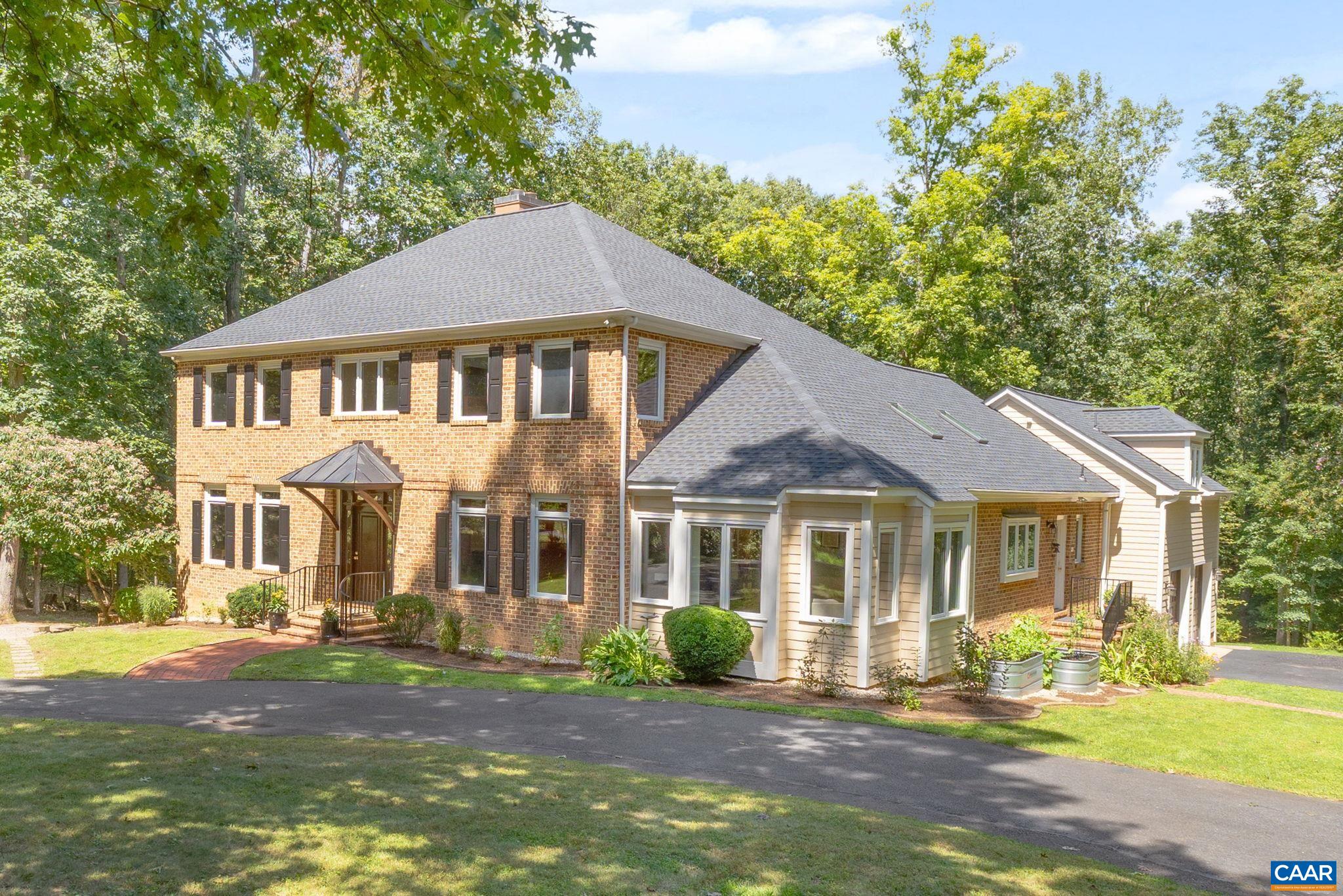 This stately brick home offers both convenience and privacy on over 4 acres backing to Ivy Creek, just minutes to downtown, UVA, Barracks Road, Shops at Stonefield, and the airport. Gracious spaces include a gourmet kitchen, formal dining room, sunroom, living room with fireplace, and multiple home office/study options. With two primary suites (including one on the main level), total of 6 bedrooms, and a versatile walk-out lower level with rec room, bedroom, full bath, and office, the layout adapts to many needs. Outdoor living shines with a deck, and extensive hardscaping (2018). Thoughtful updates include new roof (2024), resurfaced driveway (2023), and energy-efficient geothermal system. Additional highlights: side-load garage, circular drive, central vac, well irrigation system, and whole-house generator. A rare combination of location, space, and upgrades.