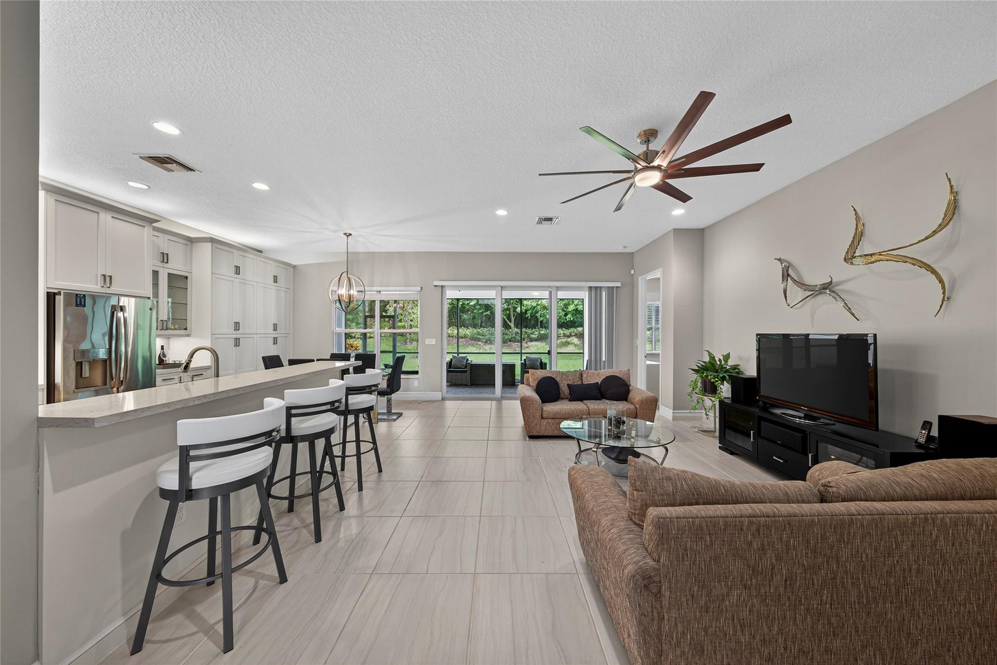 Beautiful Olivia model in Valencia Bay! This spacious split floor plan offers 3 bedrooms,, 2.5 baths, and soaring ceilings. Light-filled interiors feature impact glass, neutral porcelain tile, and an upgraded kitchen with quartz counters, abundant cabinetry, and storage. Additional highlights include a large powder room with linen closet, oversized laundry room, and screened covered patio overlooking a private landscaped large backyard. Just 8 years new, this home combines comfort, style, and access to world-class 55+ amenities including pickleball, tennis, bocce, fitness, classes, shows, games, billiards, café, and more—all in a premier gated community.