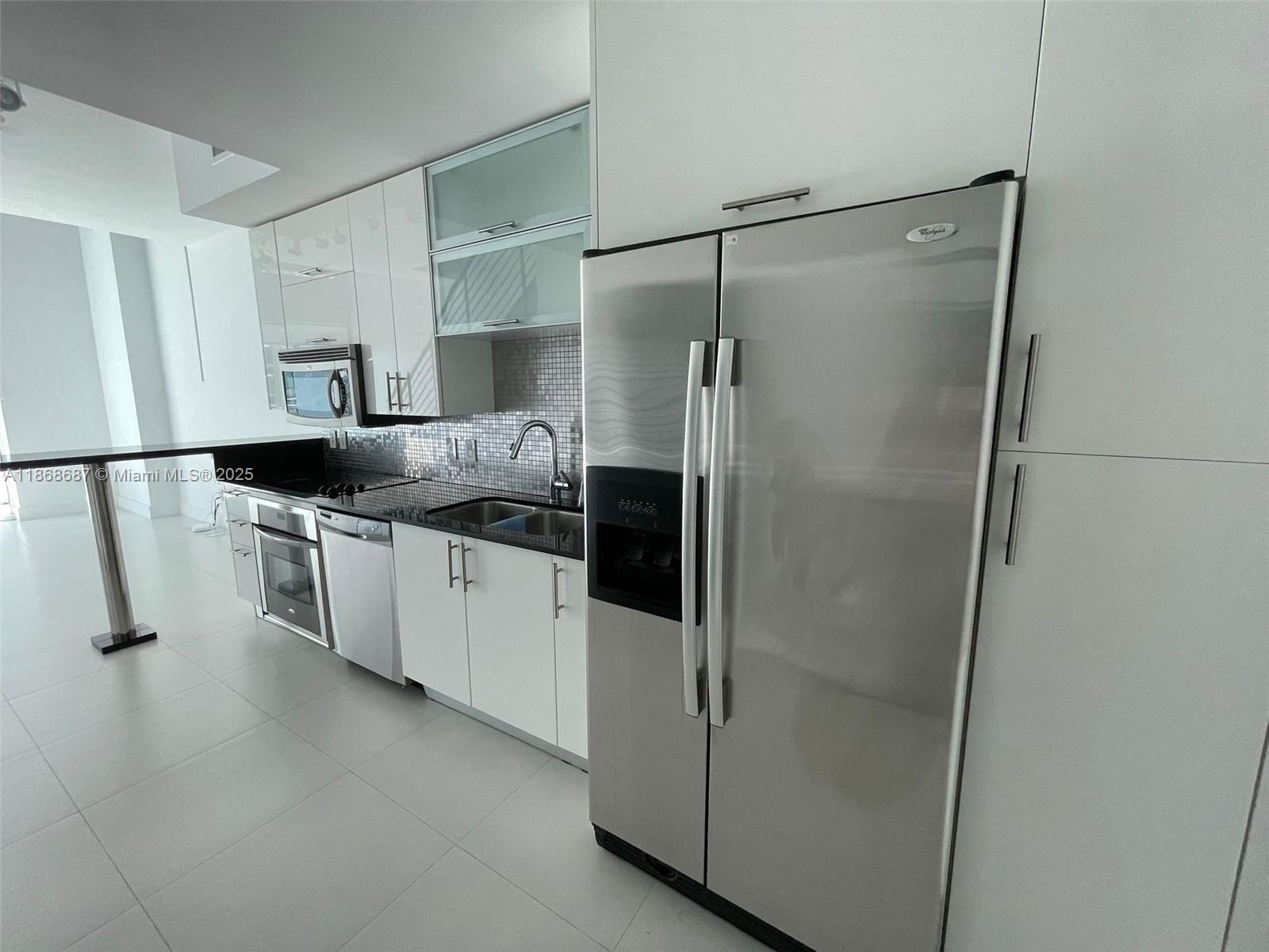 Experience contemporary loft living at Infinity at Brickell in this expansive unit featuring impressive double-height ceilings. The main level offers a stylish, modern kitchen with clean lines, a guest powder room, and striking floor-to-ceiling windows that flood the space with natural light. Upstairs, the open-concept bedroom provides a spacious walk-in closet and a well-appointed en-suite bath. Residents benefit from premium amenities including a swimming pool, state-of-the-art fitness center, and more. Ideally located just moments from the shops, dining, and entertainment of Mary Brickell Village and Brickell City Centre.