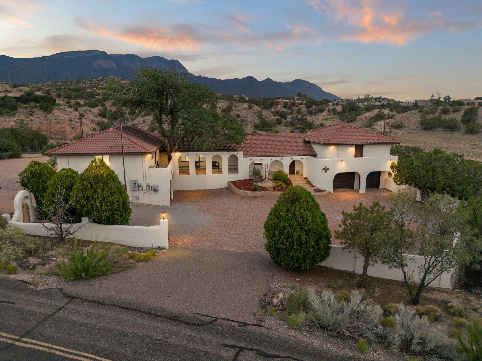 Discover the perfect blend of privacy, natural beauty, views of the Sandias and income potential in this stunning Spanish Mission style, 4-bedroom, 4-bath home nestled on 1.58 acres in peaceful Placitas. Spanning approximately 3,800 square feet, this thoughtfully designed residence includes a fully equipped attached casita, ideal for generating passive income, hosting guests, or multi-generational living and is separately metered from the main home. Owned solar, offering both comfort and long-term savings included. Step inside to discover hardwood floors, Spanish tile accents, a gourmet kitchen outfitted with granite countertops and stainless-steel appliances and center island with counter seating. The spacious layout flows effortlessly from kitchen to dining and living space.