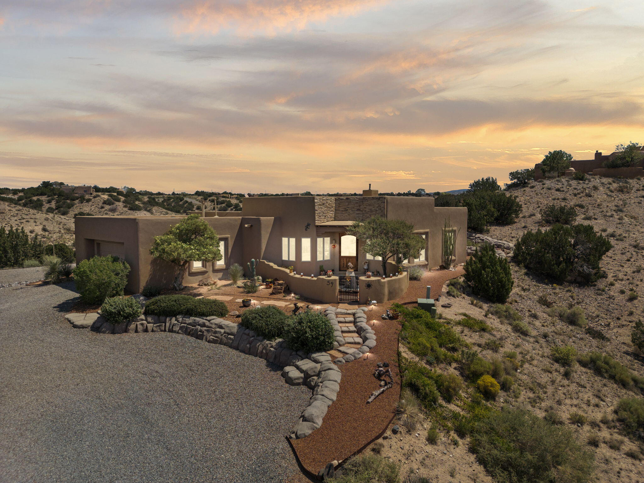 This home is a rare gem with mountain and city light views with over $50,000 in upgrades. The seamless indoor-outdoor living, thoughtful updates, & upscale yet earthy aesthetic invite comfort & sophistication. This home is perched on a 1.69-acre lot in the desired Sky Mountain Subdivision in Placitas located just minutes from I25 for easy access! Traditional Southwestern features set the tone with vigas, corbels, nichos, custom alder cabinets, and doors create artisanal charm, complemented by a welcoming open floor plan. The gourmet kitchen has a center island with counter seating, granite countertops, and stainless-steel appliances, this culinary hub flows beautifully into the great room and formal dining area--ideal for entertaining.