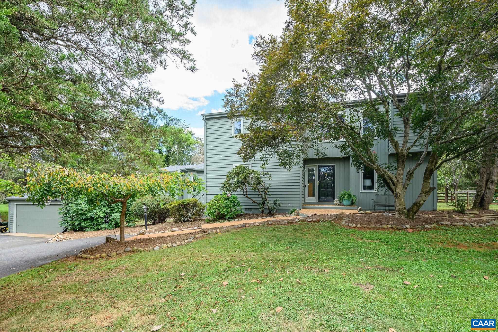 Located in the heart of Ivy, light filled Contemporary with Vaulted Ceilings, versatile floor plan, first floor living option, and beautiful hardwood floors.  Expansive entertaining spaces with wonderful flow from the living room to open kitchen/den with fireplace and dining room.  Total of 4 bedrooms and 3 full  recently renovated baths. Many updates including replacement windows, interior and exterior painting and roof.  Country like setting with fruit tree lined driveway and small koi style pond. Lovely patio with block fireplace overlooks sunny,  park-like backyard. Easy access to Neighborhood Common area with over 40 acres of extensive nature trails and wooded path to the historical Blue Ridge Swim Club. Detached garage, paved driveway, extra parking. 2 minutes to Ivy Elementary.  Close to Wine Trails, Shopping, Medical Facilities & UVA. Minutes to Crozet, Henley Middle & Western Alb High School.