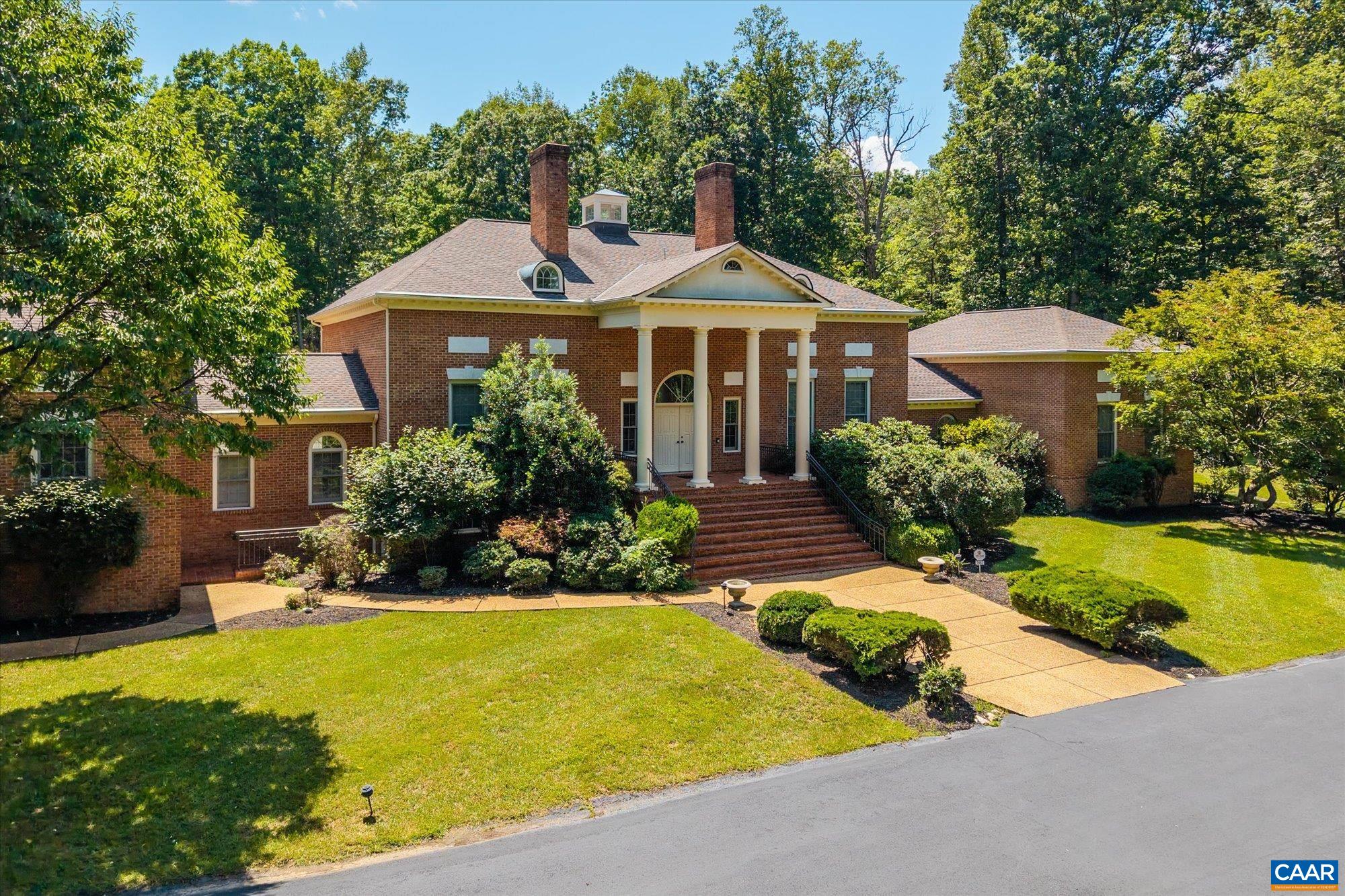 Privately sited on 21 landscaped acres, this stately brick residence blends timeless architecture with modern comfort. The home offers five bedrooms, seven full and one half baths, soaring ceilings, elegant moldings, and four fireplaces. A grand living room anchors the main level, complemented by a richly appointed home office, expansive primary suite, and guest quarters with loft. The finished walk-out lower level includes a wet bar and wine cellar—ideal for recreation and entertaining. Outdoor features include a swimming pool, clay tennis court, mature landscaping, and a sweeping lawn. A generator and garage enhance everyday functionality. An adjacent 21-acre parcel is also available. An estate offering privacy, scale, and refined living—minutes from town, yet a world apart.