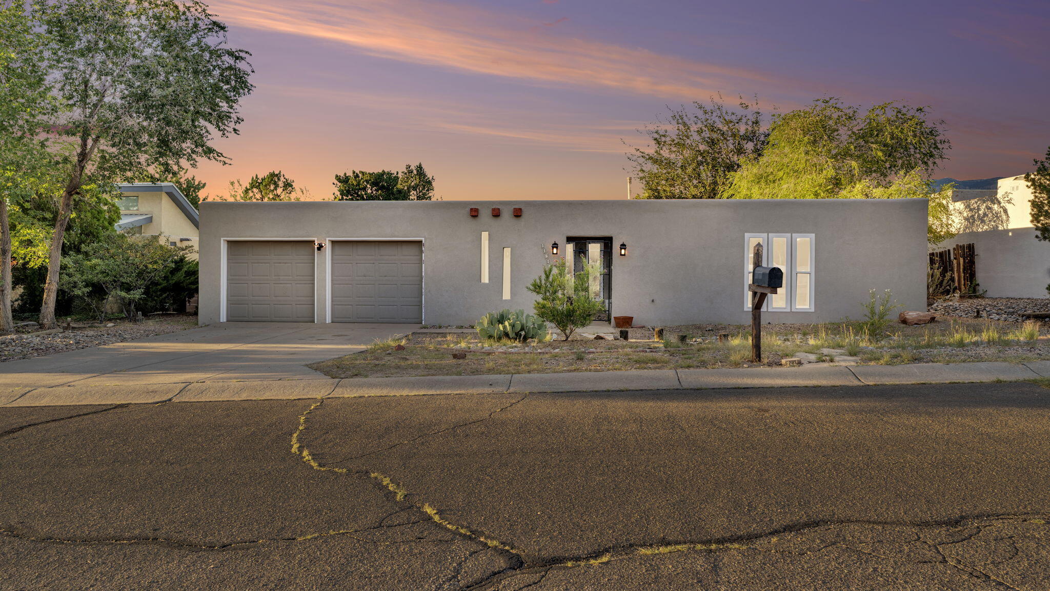Welcome to this 4-bedroom, 2-bath Pueblo Revival style home with contemporary updates, ideally located in the NE Heights. The inviting entry opens to a spacious living room with a stone-accented fireplace, built-in shelving, and wood-look tile throughout. The updated kitchen offers natural wood cabinetry, quartz countertops, stainless steel appliances, and plenty of storage. Bedrooms are filled with natural light, offering flexible layouts for work or relaxation. Step outside to a beautifully landscaped backyard with a covered patio, raised garden beds, artificial turf, and a storage shed. Enjoy peace of mind with a newer TPO roof, heating, and refrigerated air. A two-car garage adds convenience. Don't wait--homes like this move fast, so act now to make it yours!