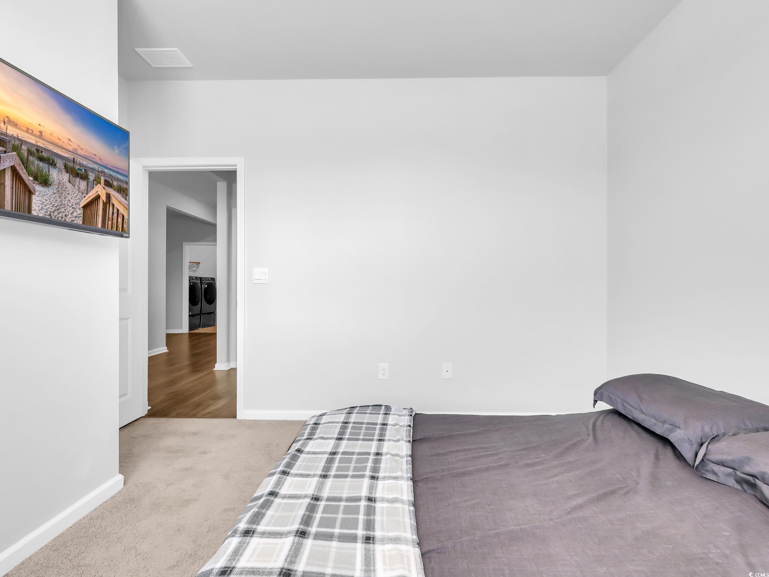 Bedroom featuring carpet and separate washer and dryer